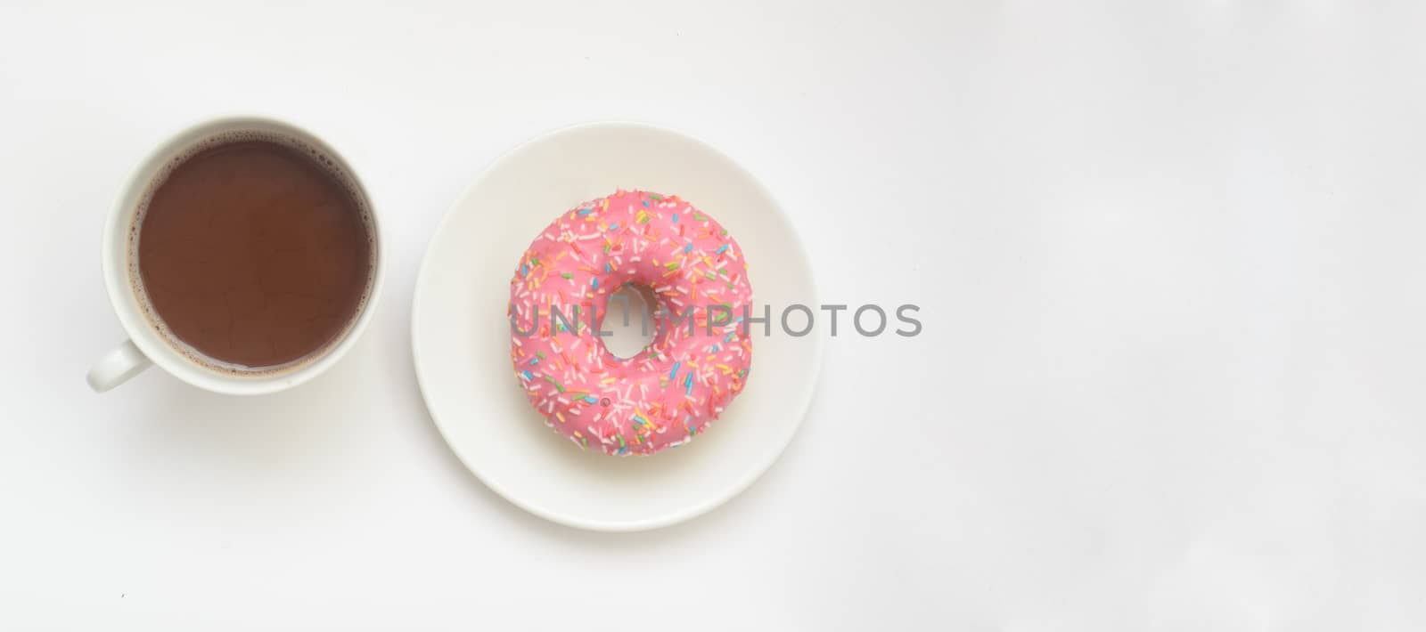 A cup of cacao drink and pink donut on white background, space for text.