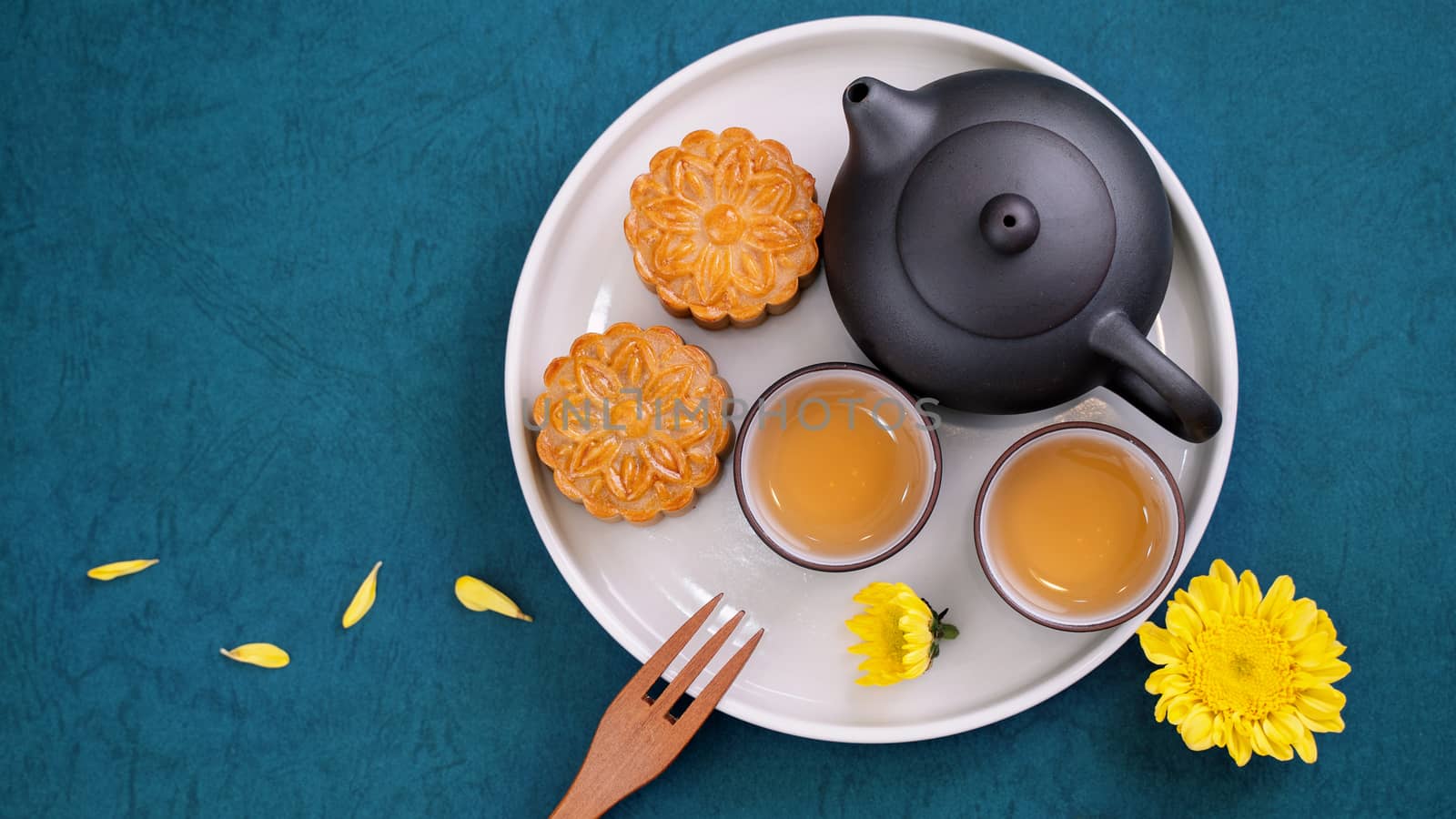 Moon cake for Mid-Autumn Festival, delicious beautiful fresh mooncake on a plate over blue background table, top view, flat lay layout design concept.