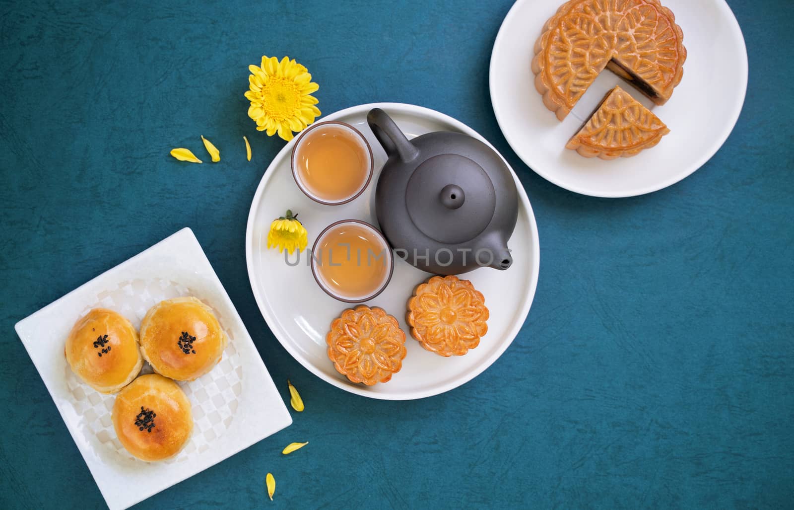 Moon cake for Mid-Autumn Festival, delicious beautiful fresh mooncake on a plate over blue background table, top view, flat lay layout design concept.