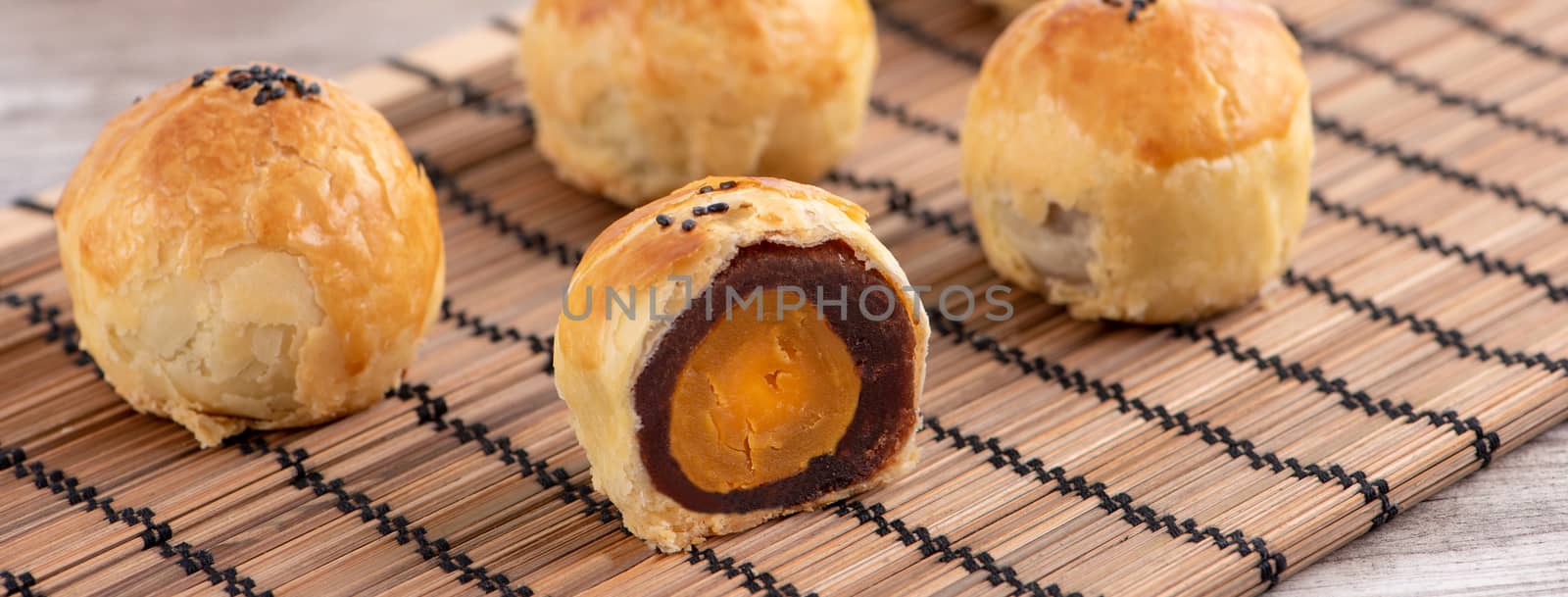 Moon cake yolk pastry, mooncake for Mid-Autumn Festival holiday, top view design concept on bright wooden table with copy space