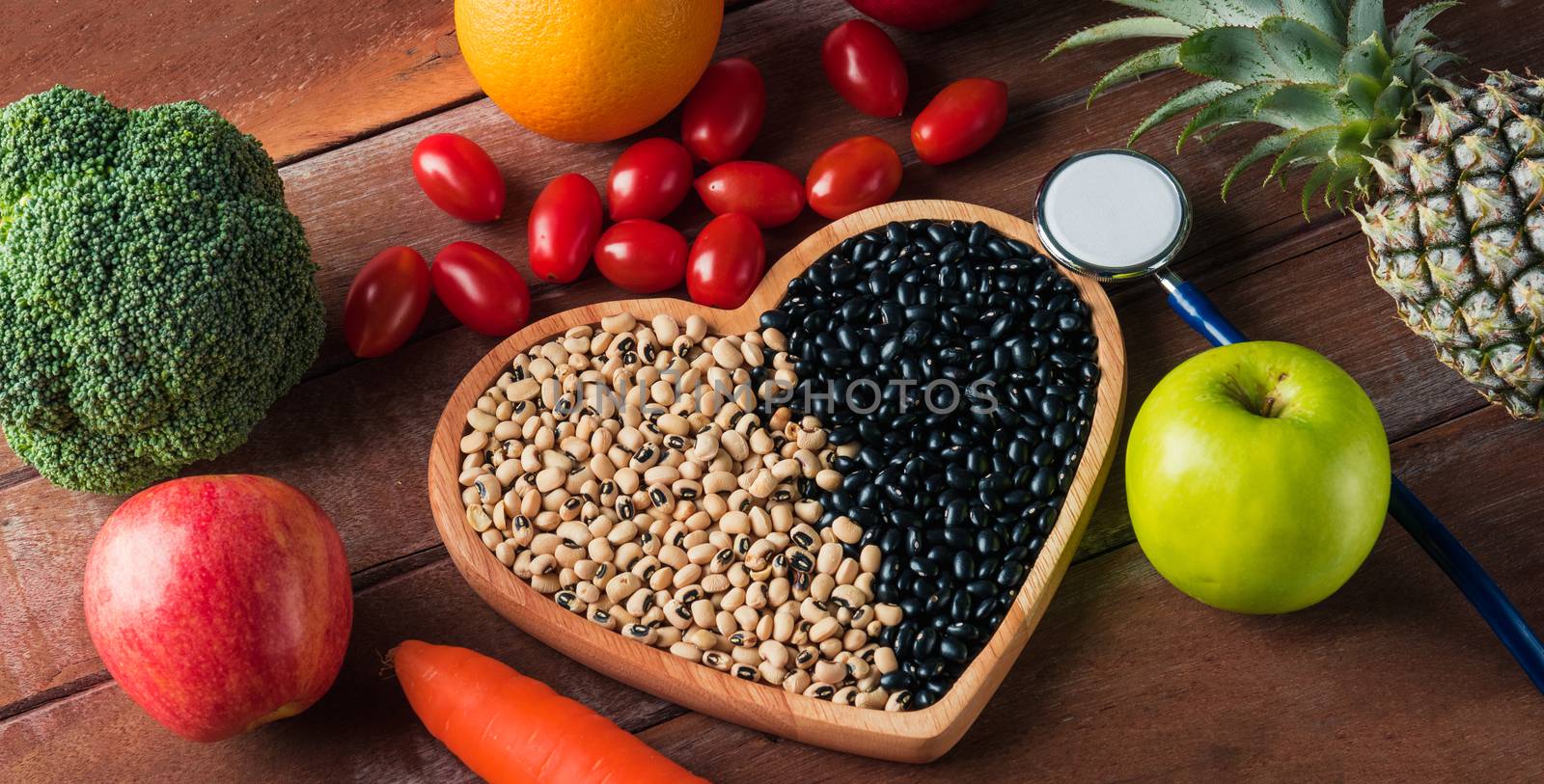 World food day, Top view of various fresh organic fruit and vegetable in heart plate and doctor stethoscope, studio shot on wooden table, Healthy vegetarian food concept