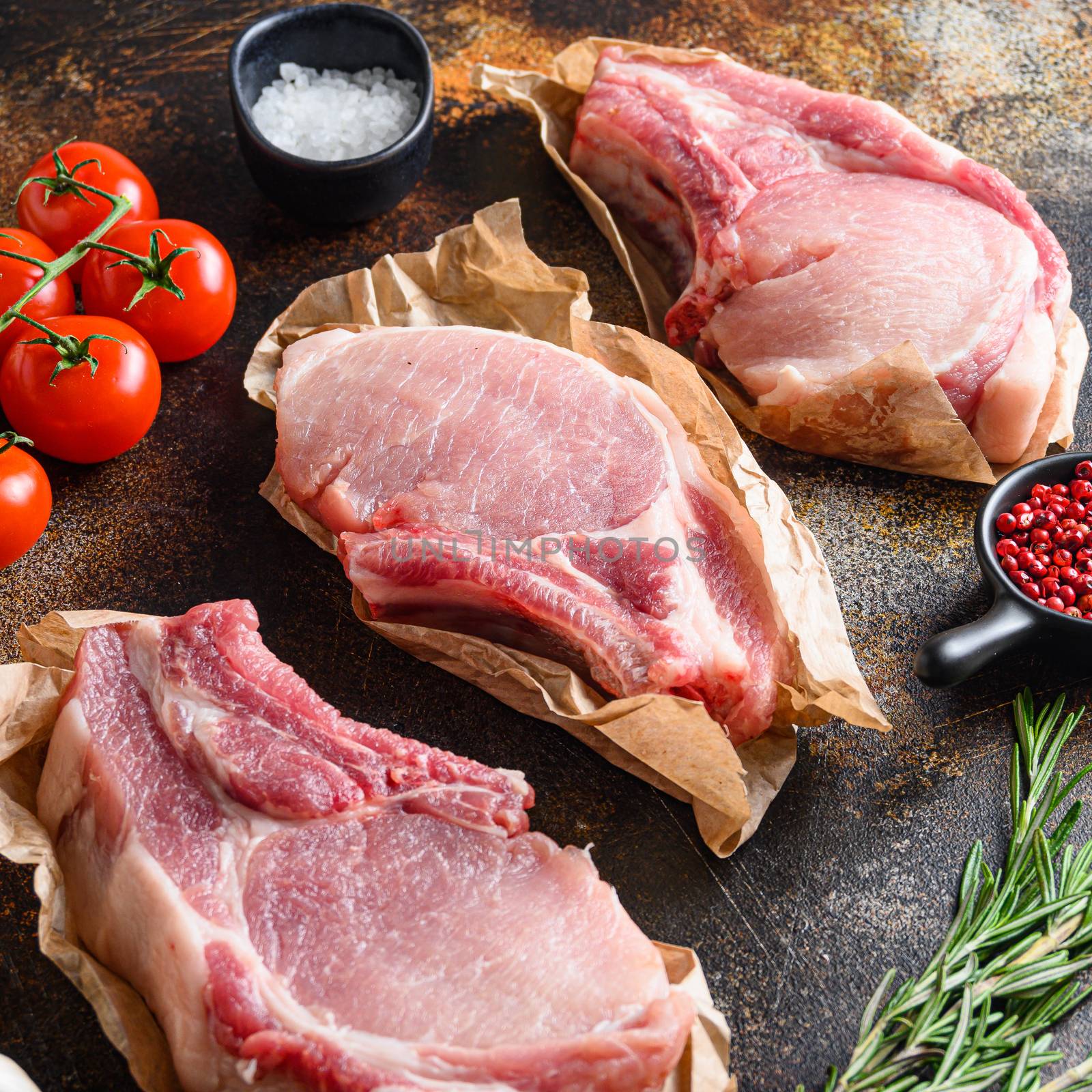 Tree bunch raw pork chops arranged with herbs, oil and spices. Cooking meat. On dark background Square. by Ilianesolenyi