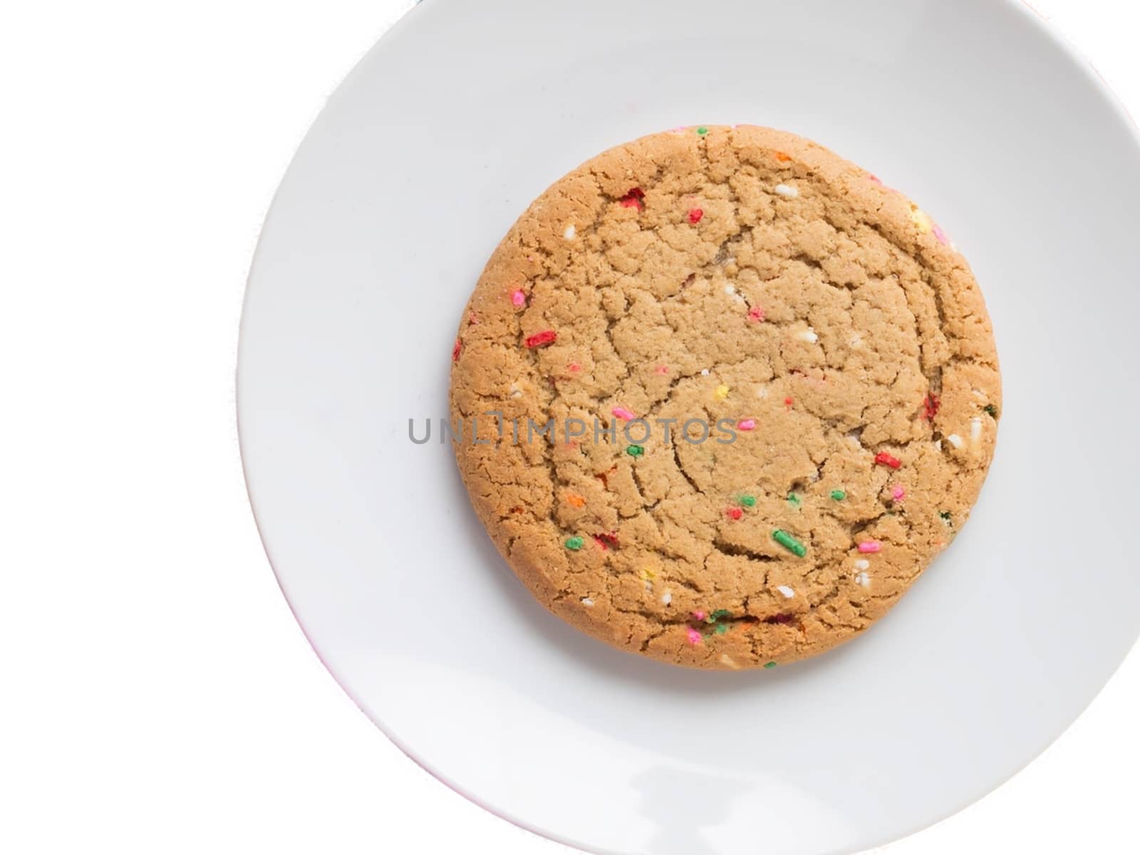 Almond giant biscuits with coloured sugar pieces on a white platter.