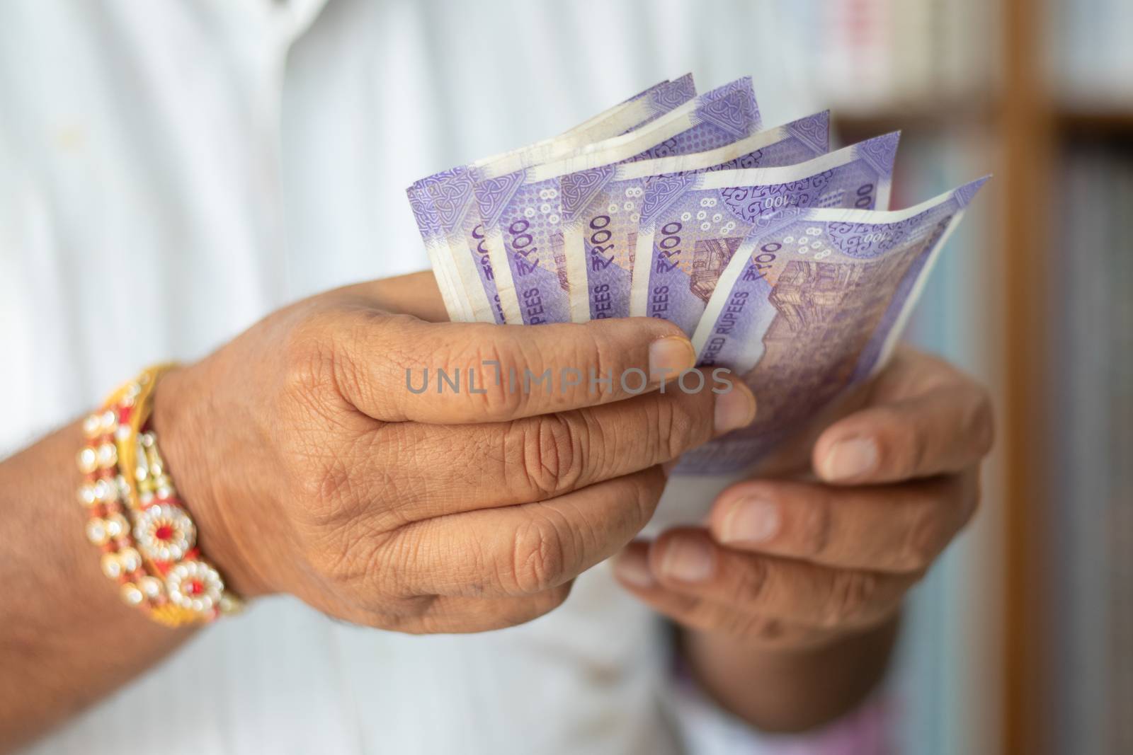 Close up hands Counting Indian Currency notes at cloth shop - Concept of back to business, profit, making money and reopen economy.