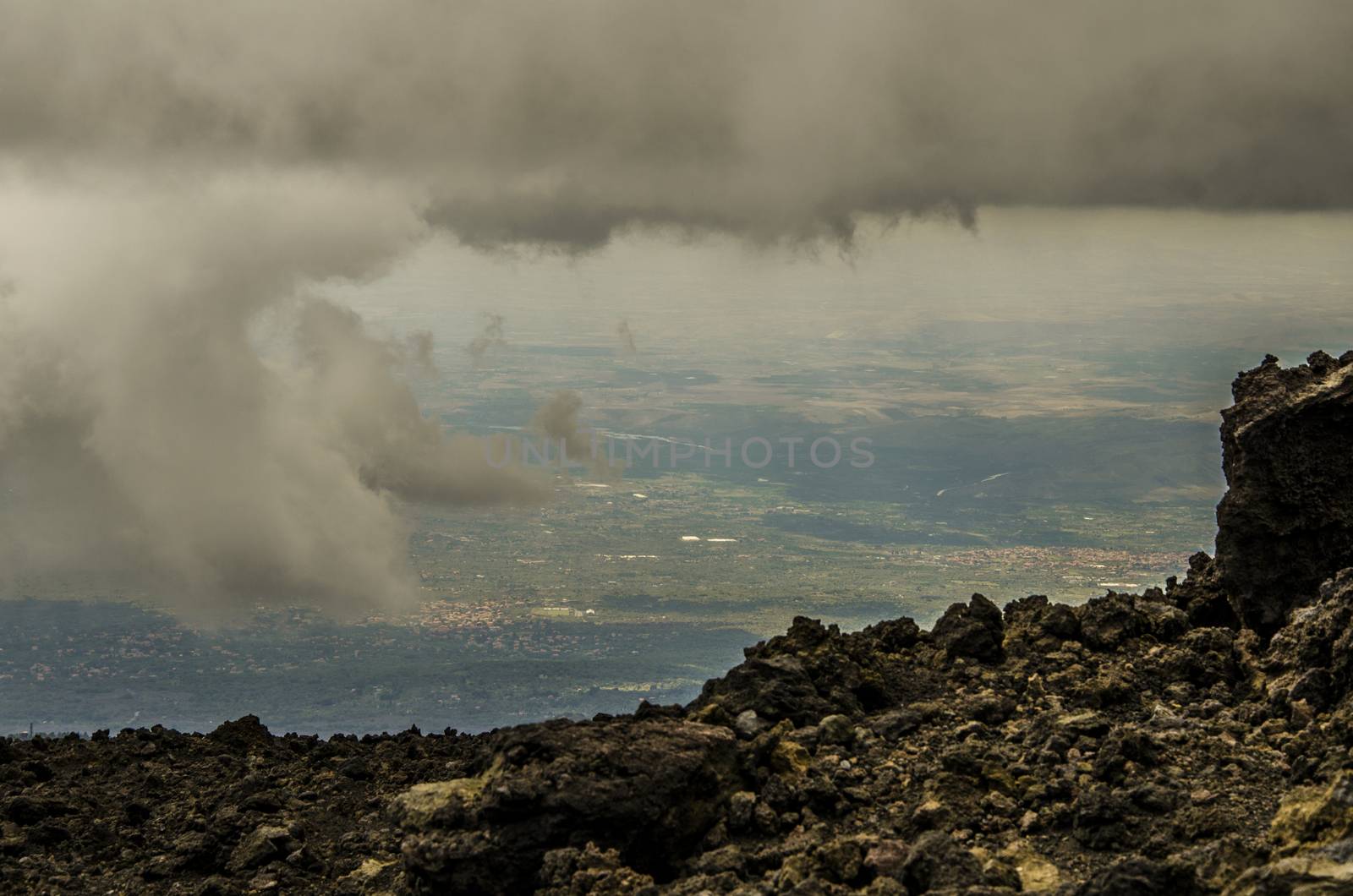 View of Sicilian territory between clouds from the top of Etna volcano