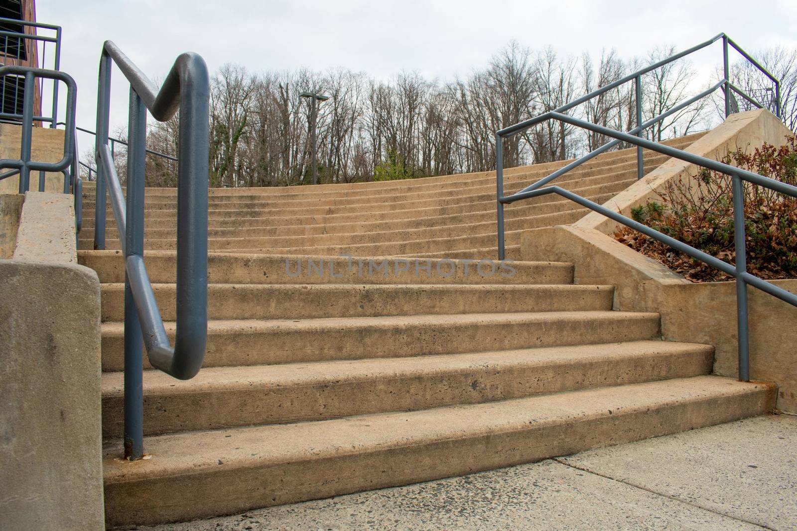 A Set of Concrete Steps With a Green Railing in a Shopping Cente by bju12290