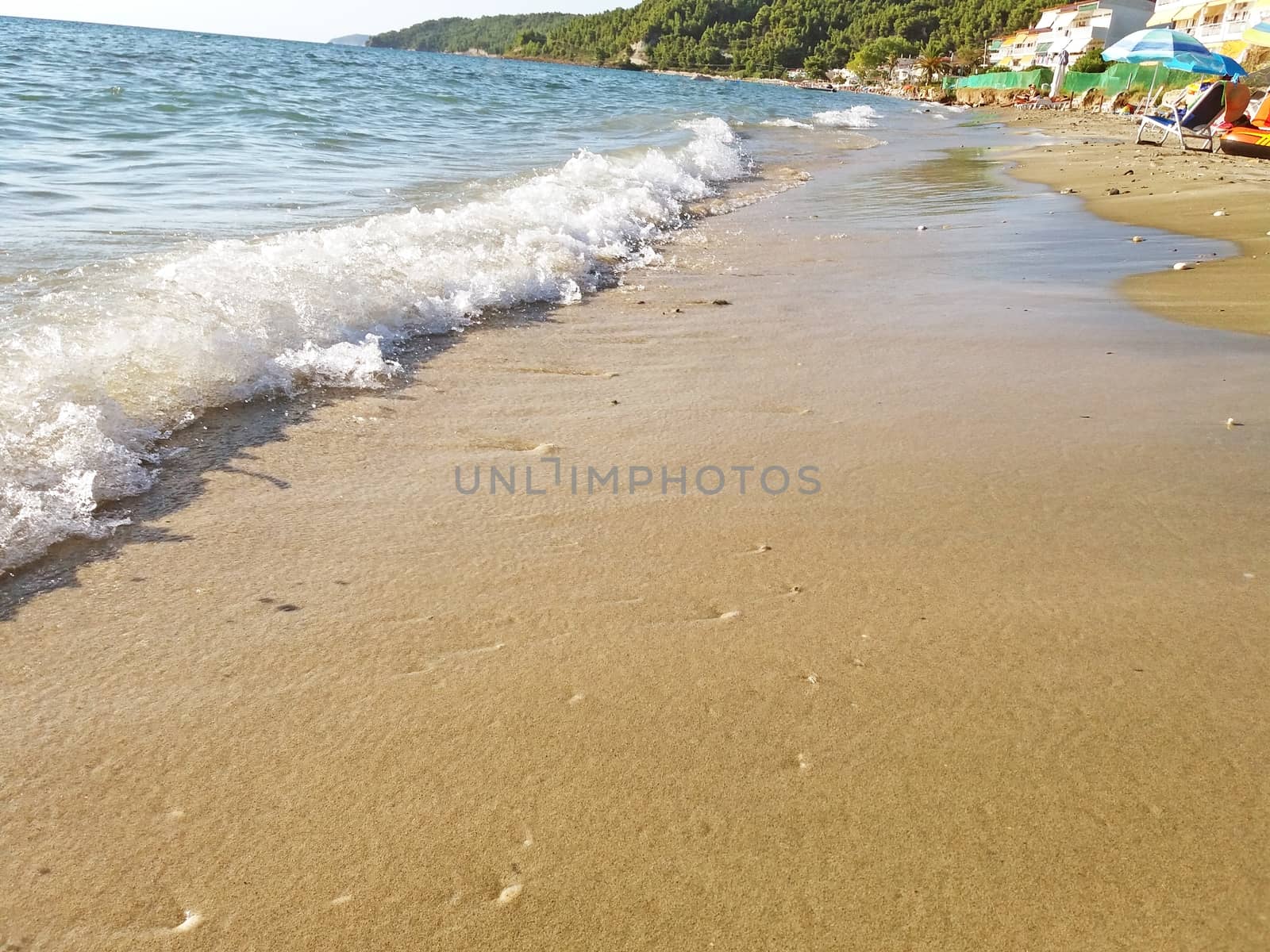 At the beach, Mediterranean Sea in Greece, the waves of the sea