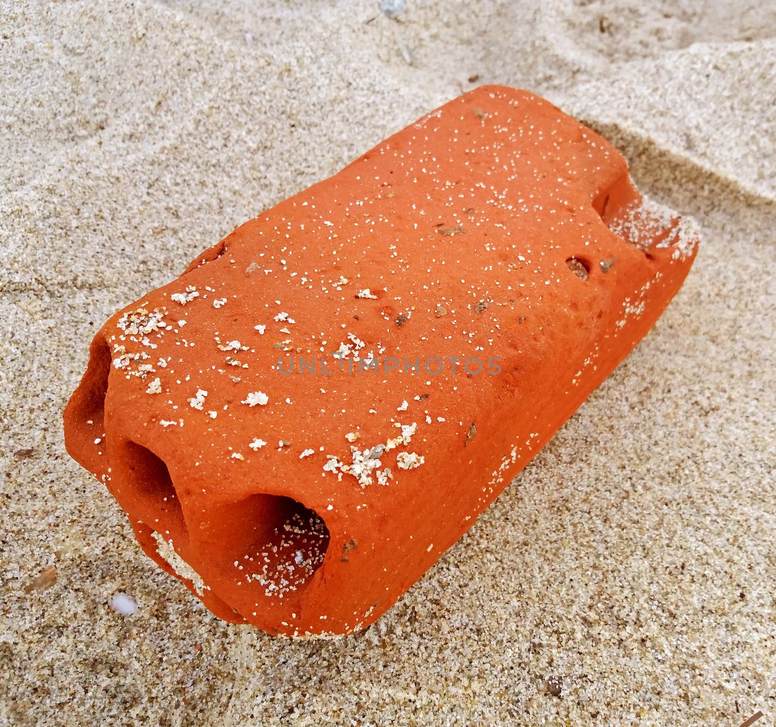 Brick polished by Mediteranean sea, on the sandy beach