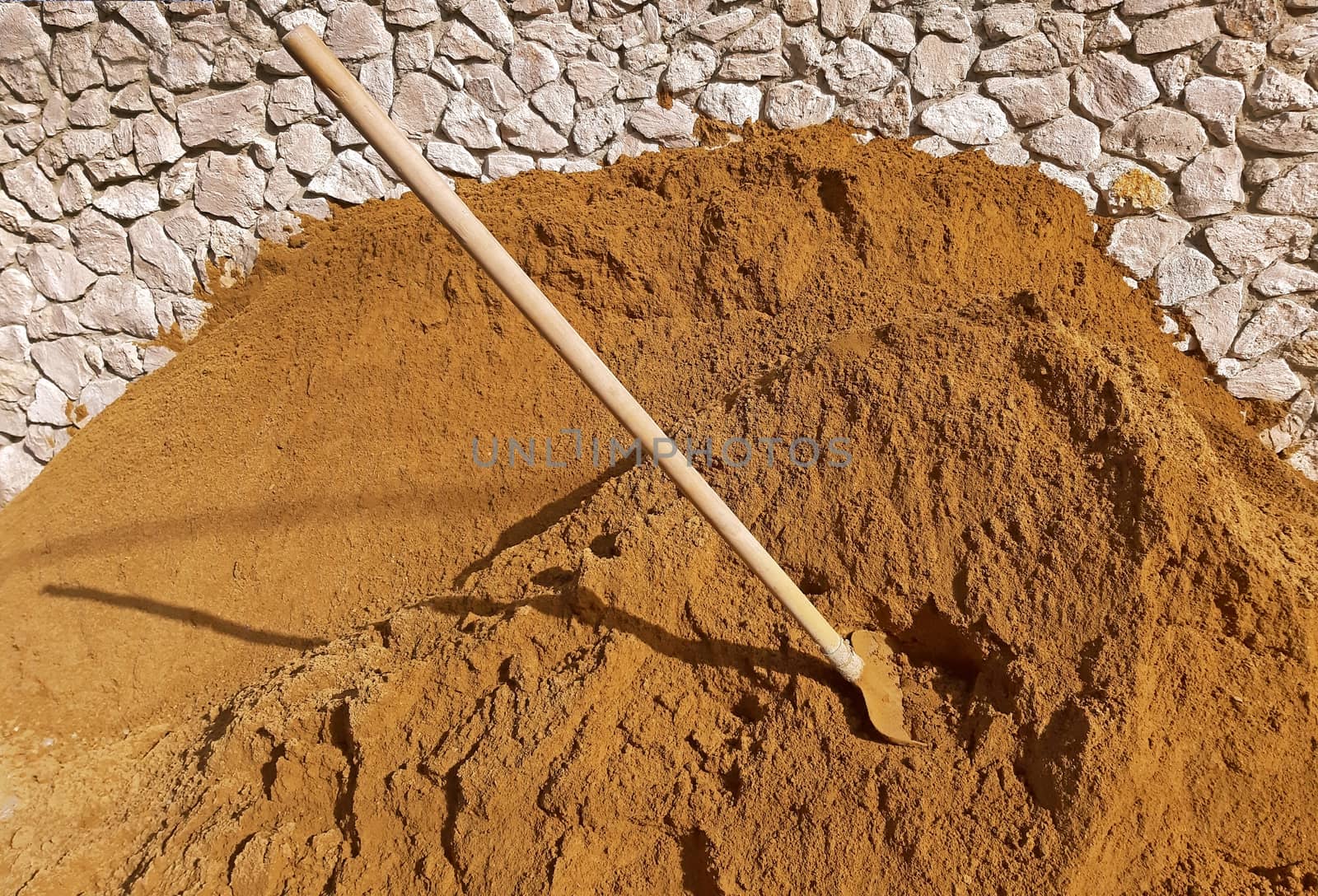 Construction sand and a shovel in the sand.