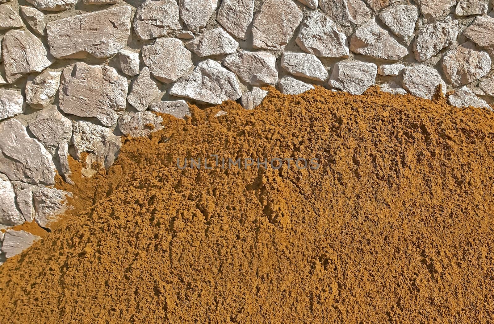 A lot of Construction sand near a wall background by Mindru