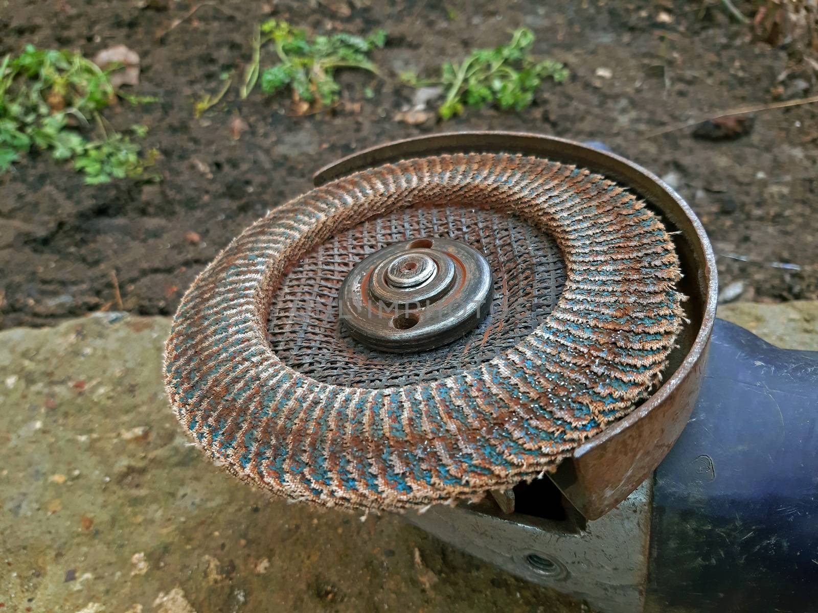 Electric sander with a used disc close up.