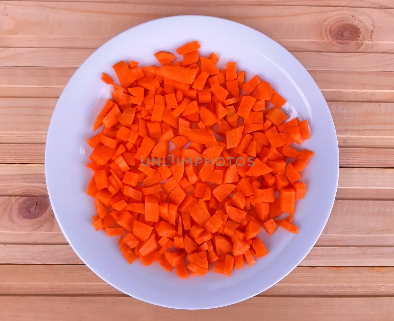 Carrot cut off into a plate on wooden background.