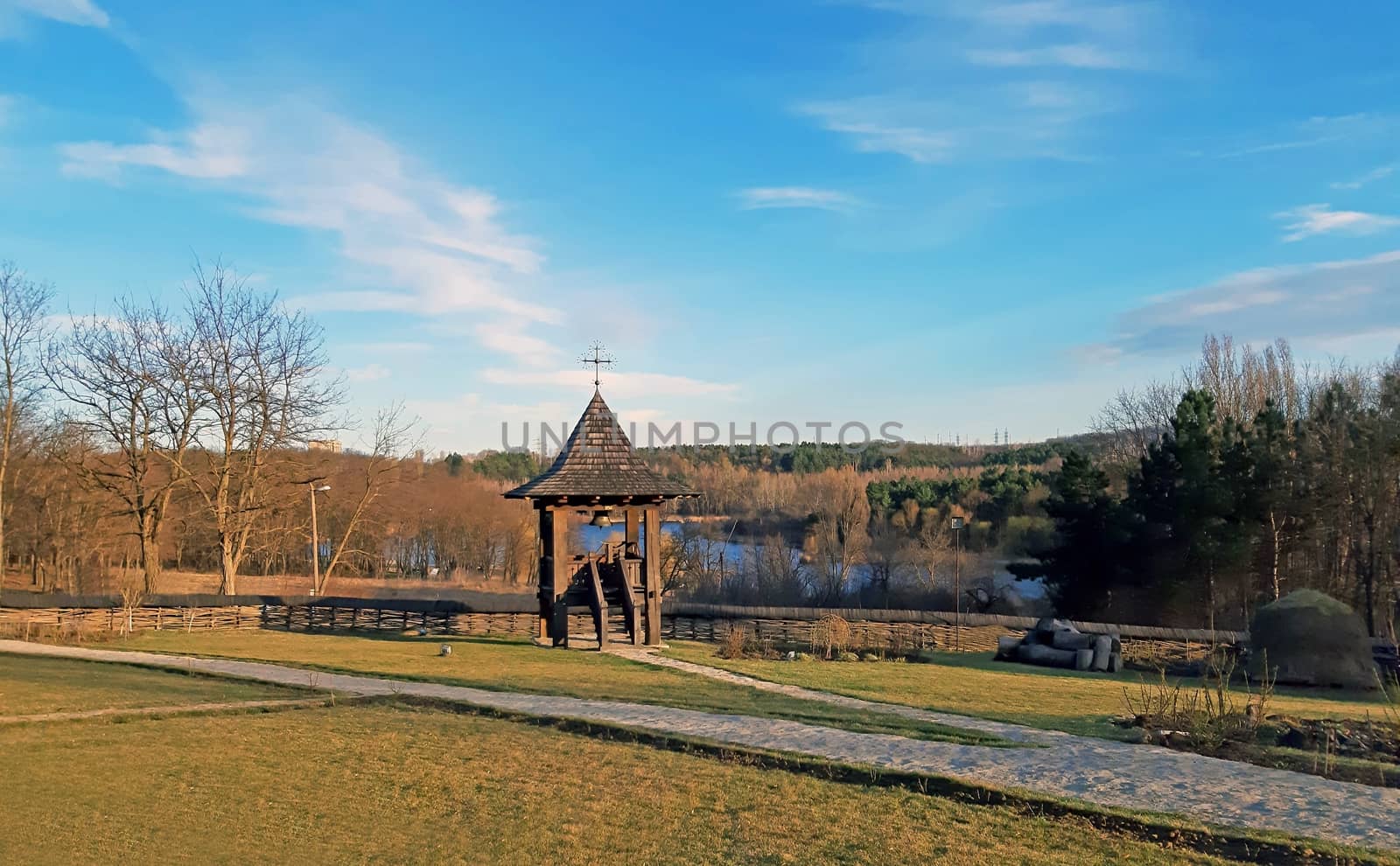 The courtyard of a church, and a lake in the background.