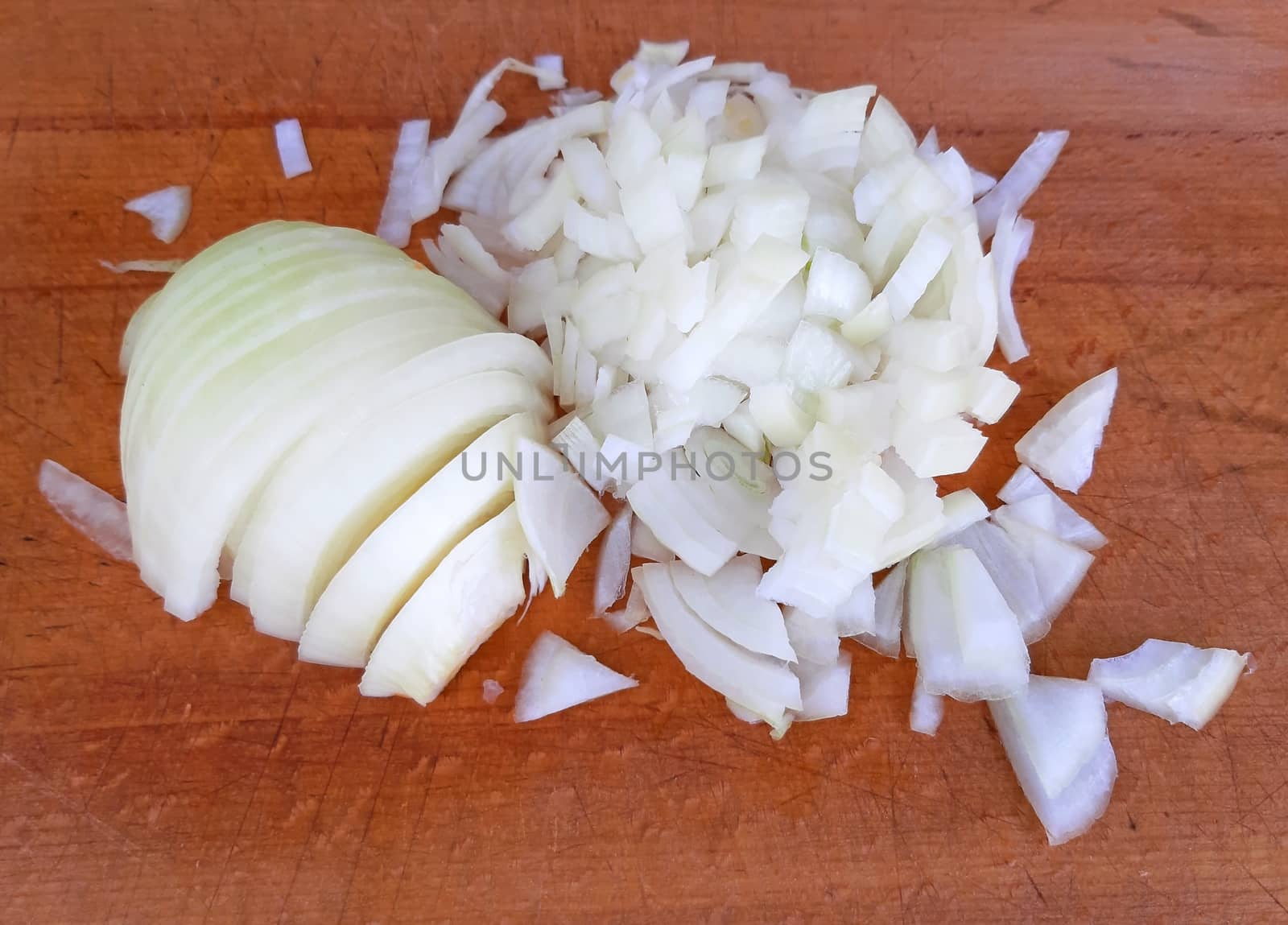 Onion peeled and cut on wood background by Mindru