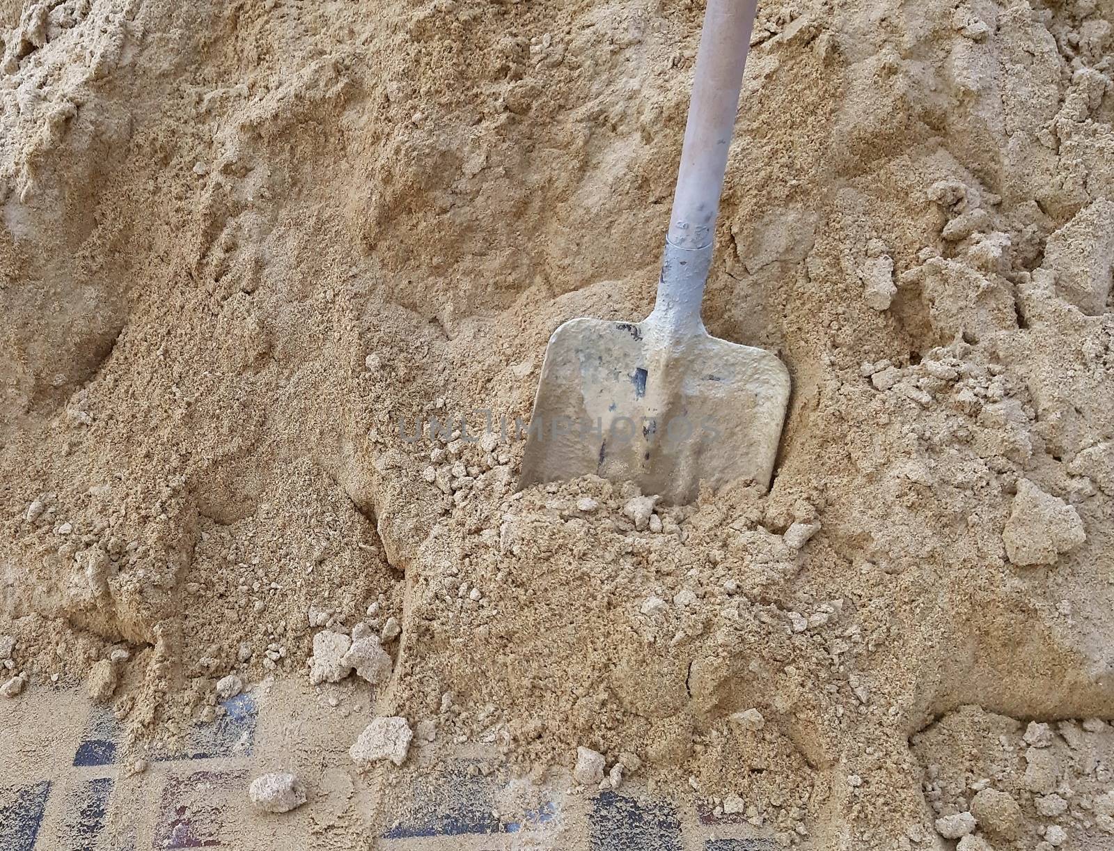 Shovel in the sand. Construction work concept.