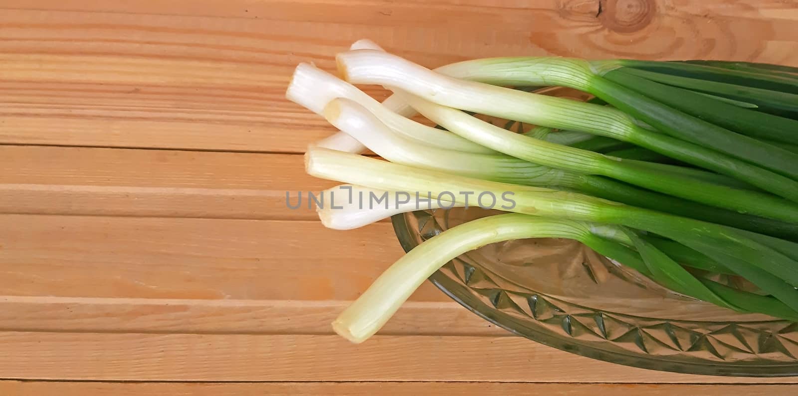 Fresh healthy onion queues on wood background.