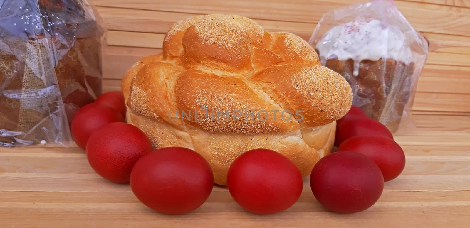 Easter red eggs and homemade bread and cakes. Easter concept by Mindru