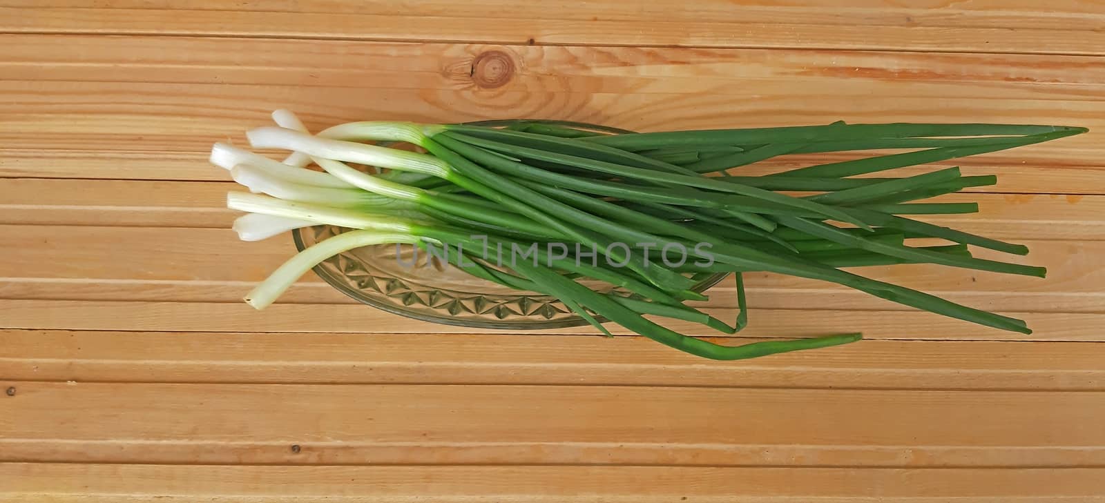 Spring onions and fresh on wooden background by Mindru