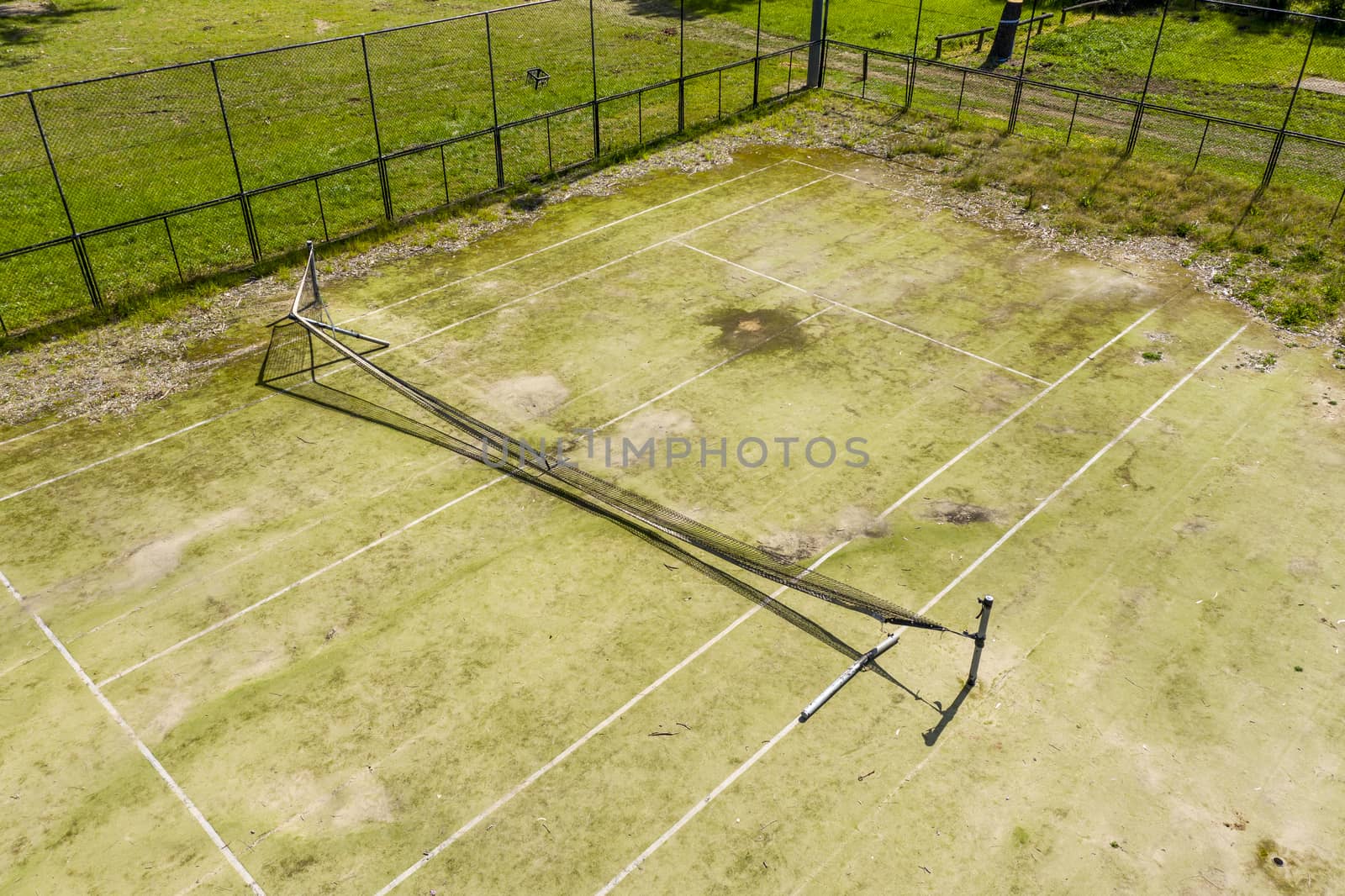 An old unused tennis court in a public park in a small regional by WittkePhotos