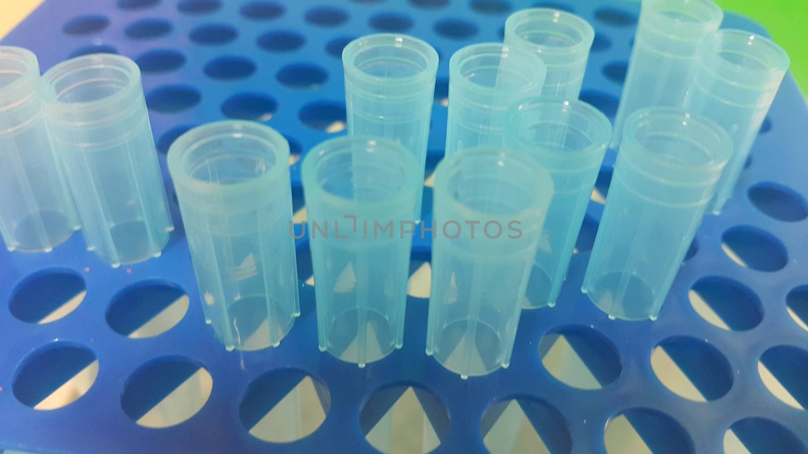 Close up view of blue micro litre tips in microtip box with empty holes. Reseach lab. tool for accurate measurement.