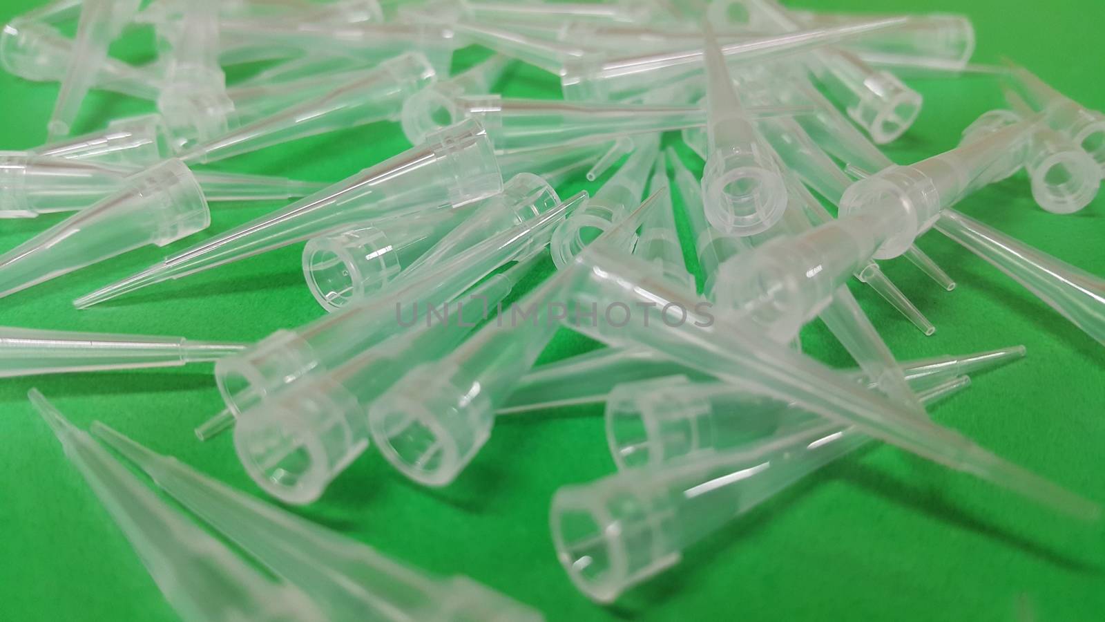 Close up view of micro litre tips on green floor sheet with empty holes. Reseach lab. tool for accurate measurement.