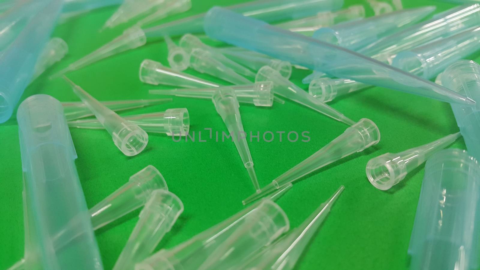 Close up view of micro litre tips on green floor sheet with empty holes. Reseach lab. tool for accurate measurement.