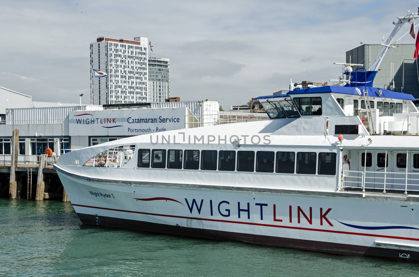 Portsmouth, UK - September 8, 2020: One of the Wightlink passenger catamaran ferries docked at the Portsmouth Harbour terminal on a sunny afternoon on the south coast of Hampshire.  The ferry links Portsmouth to Ryde on the Isle of Wight. 