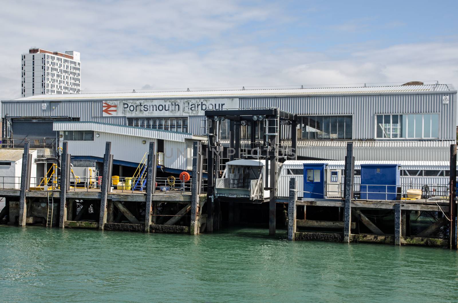 Portsmouth, UK - September 8, 2020: View from the sea of the exterior of Portsmouth Harbour railway station which allows train passengers to transfer straight to ferries to the Isle of Wight and Gosport.  