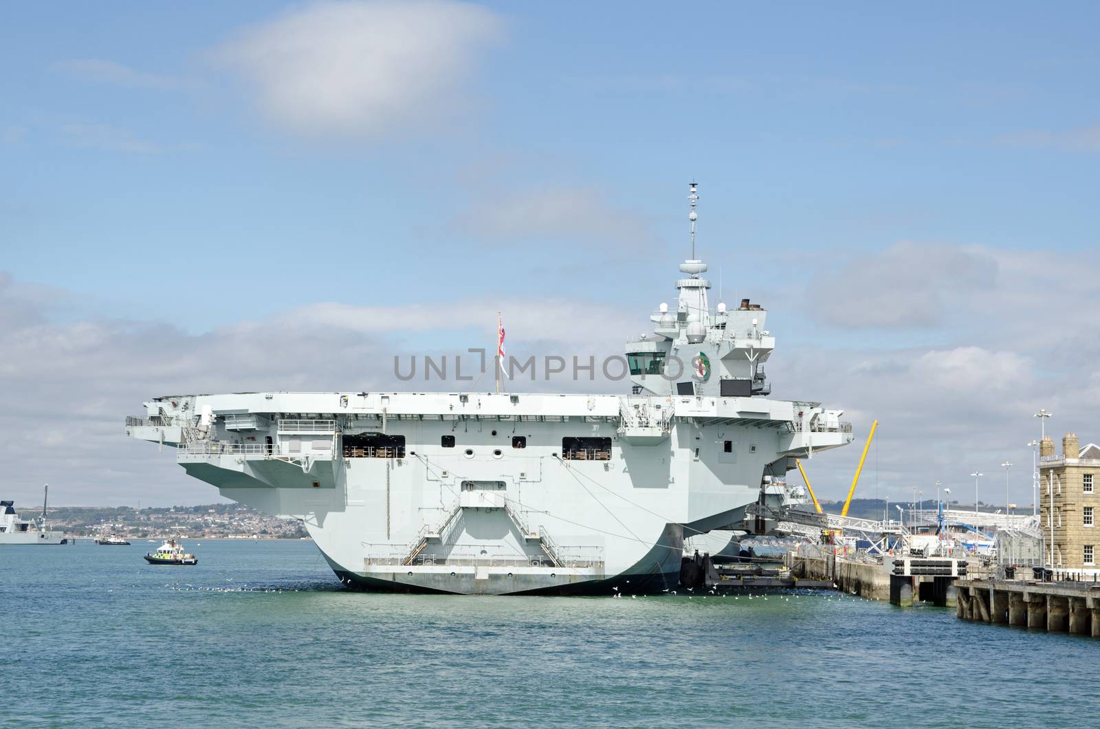 Stern of the massive Queen Elizabeth Aircraft Carrier docked at Portsmouth Harbour, Hampshire.  The Royal Navy ship is the largest in the fleet. 