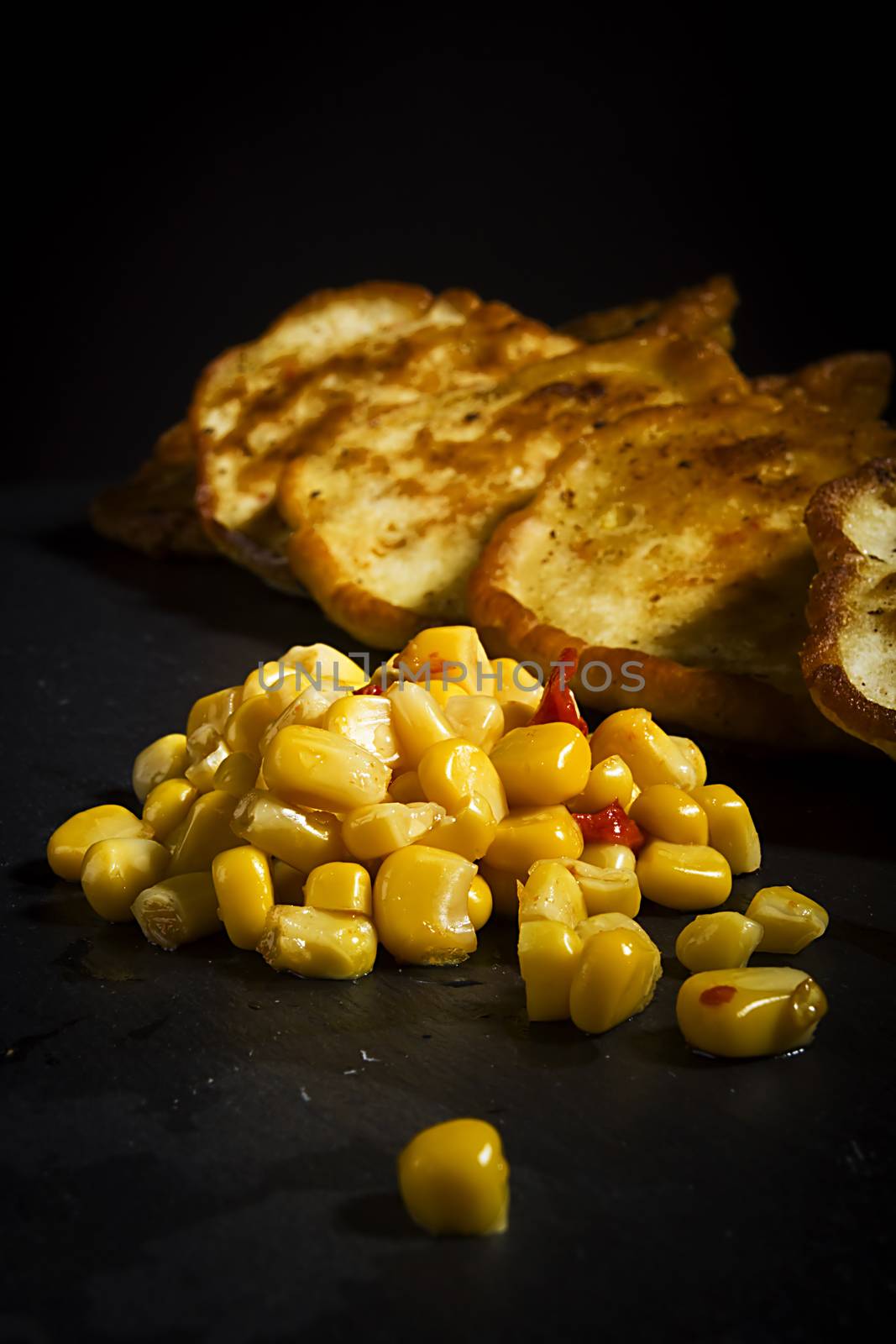 Corn and corn pancakes on black background