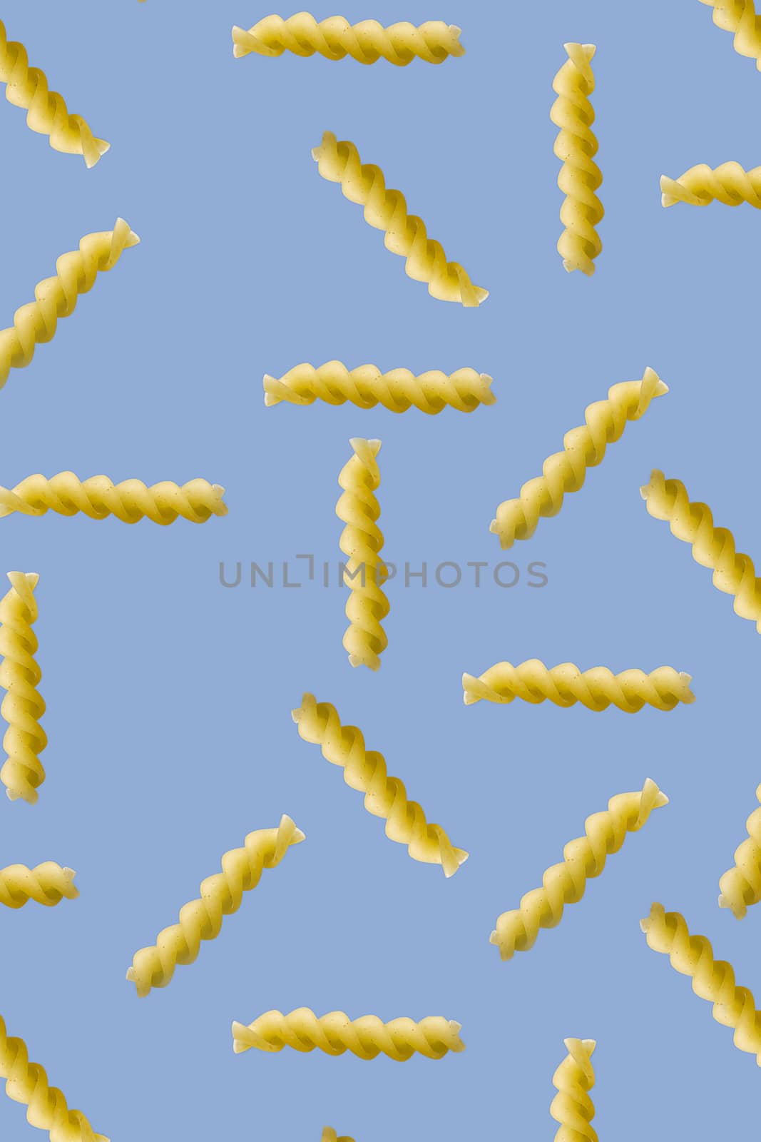 Fusilli pasta random flat lay on blue background without shadow. can be used as raw pasta background, poster, banner not pattern. by PhotoTime