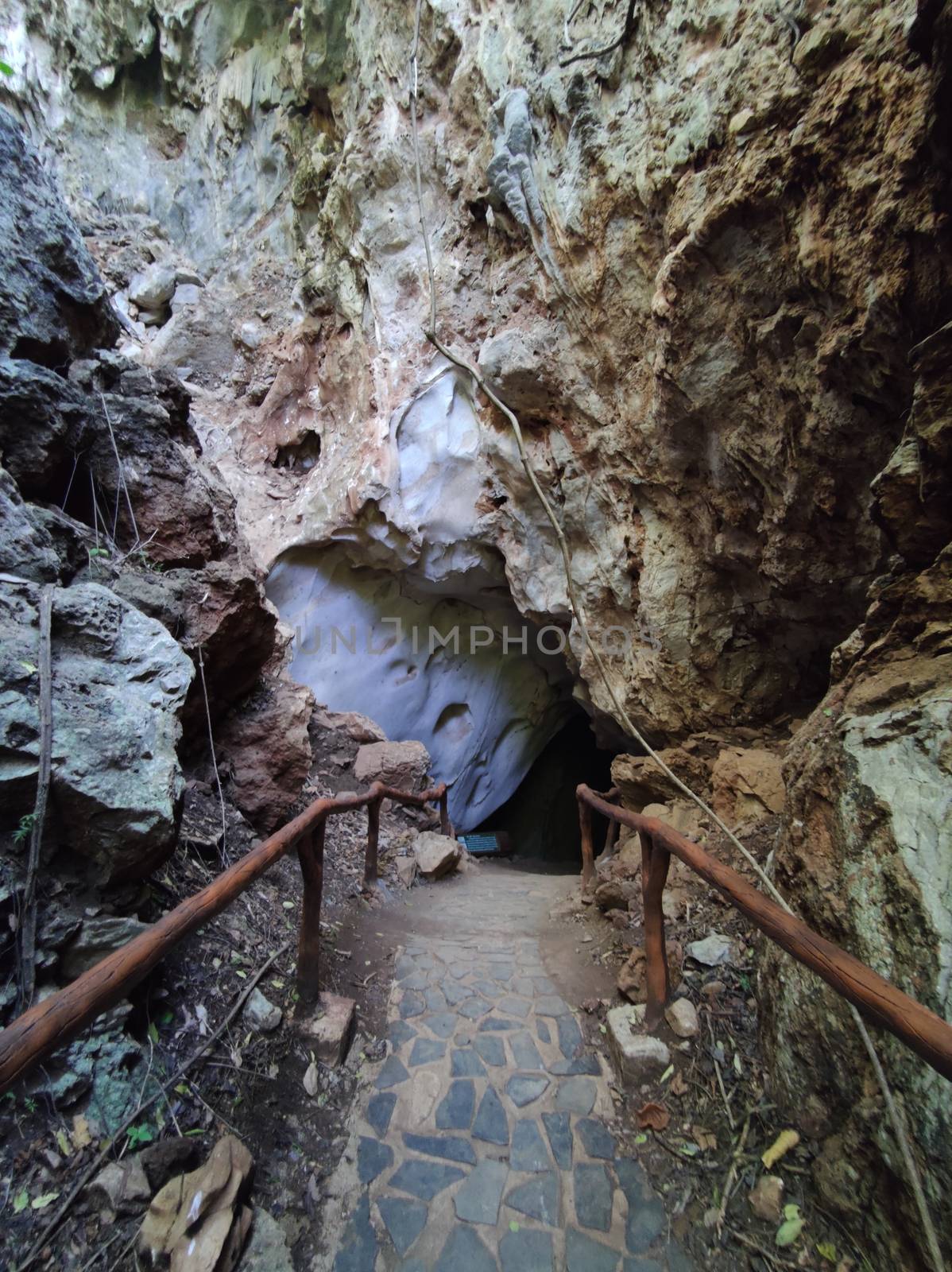 vertical photo of cave entrance with handrail in Thaailand