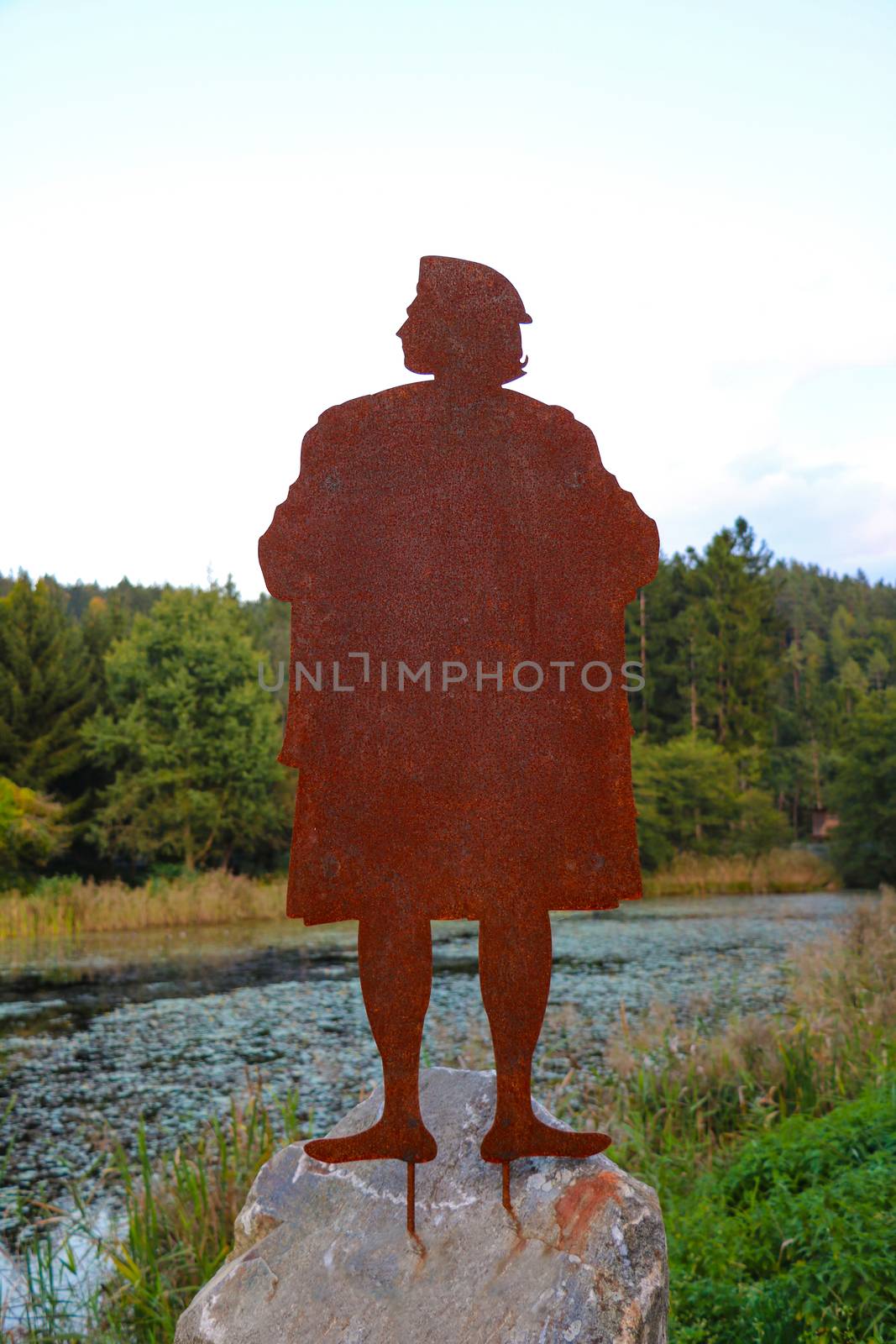 A rusty iron statue on a large stone