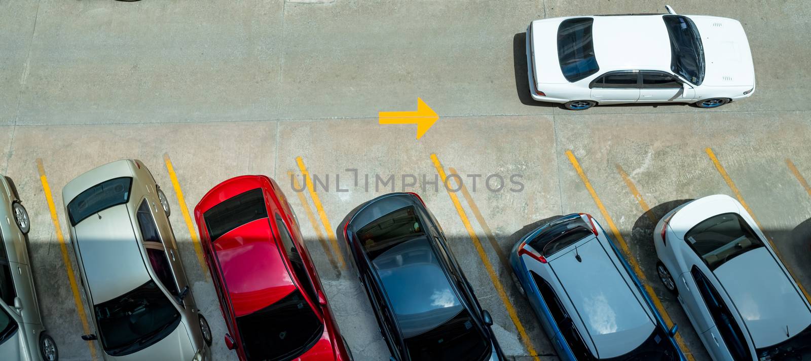 Top view of car parked at concrete car parking lot with yellow l by Fahroni