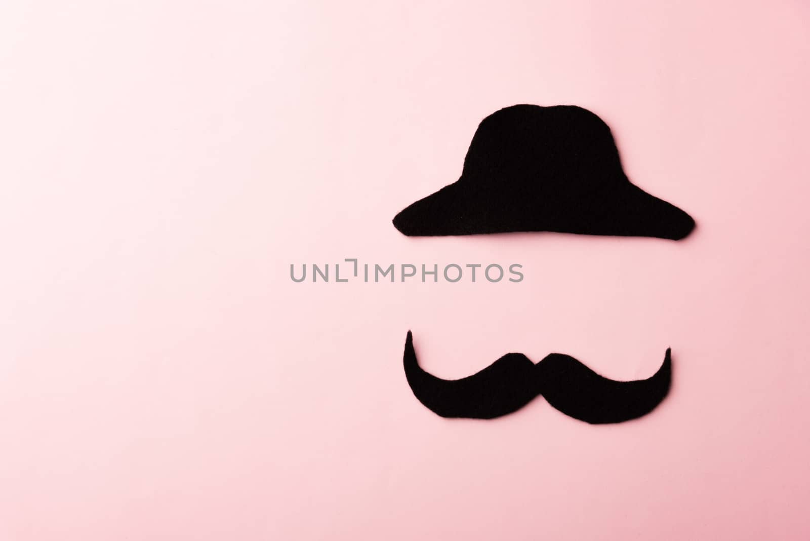 Black mustache and cap, studio shot isolated on pink by Sorapop