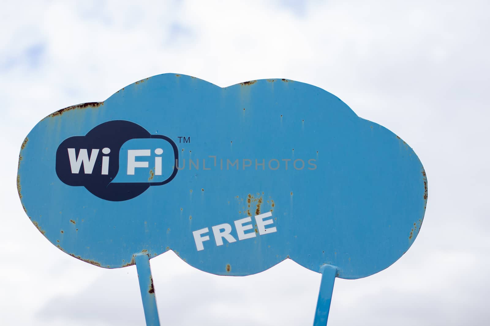 A blue sign in the Park that says WiFi. Wireless Internet access