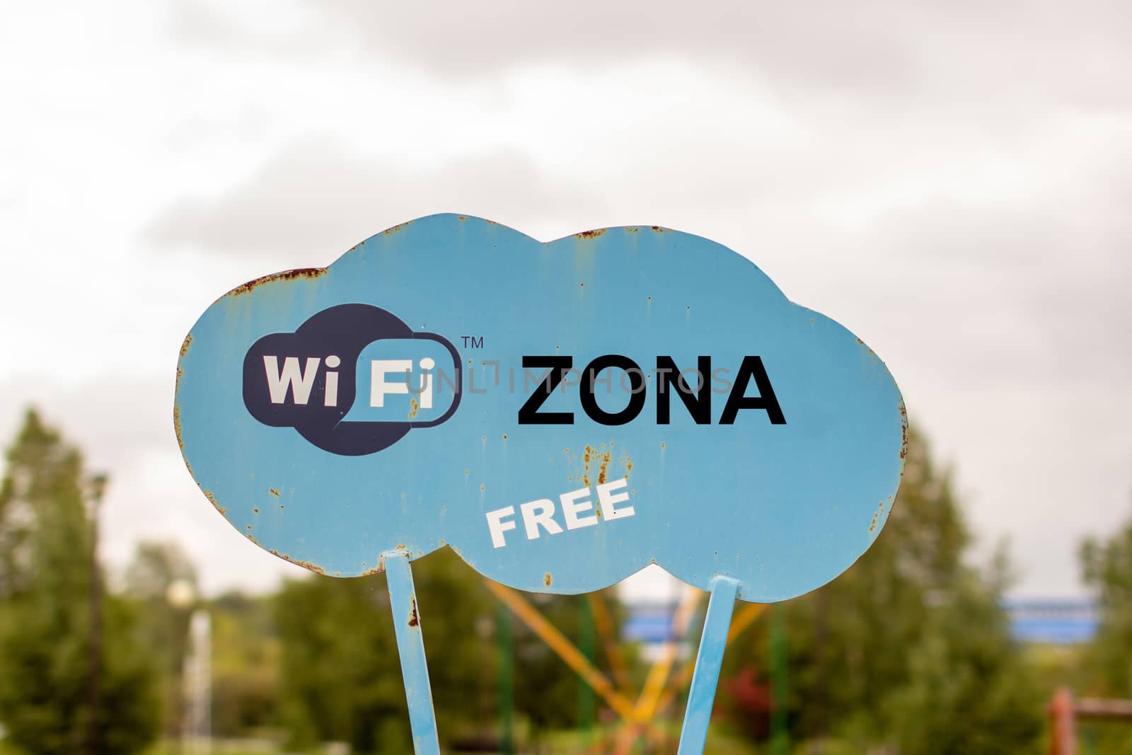 A blue sign in the Park that says WiFi.  by AnatoliiFoto