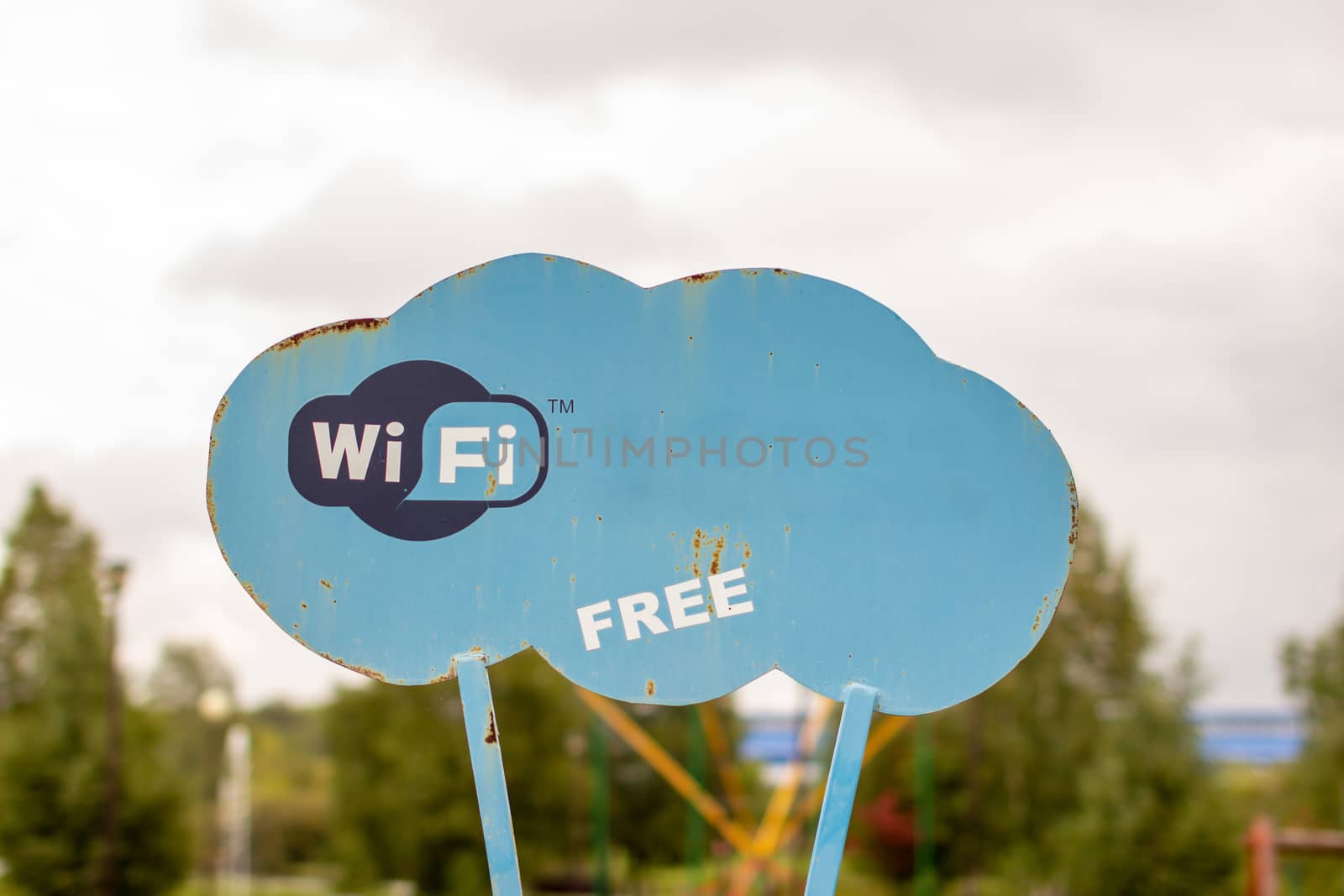 A blue sign in the Park that says WiFi. Wireless Internet access