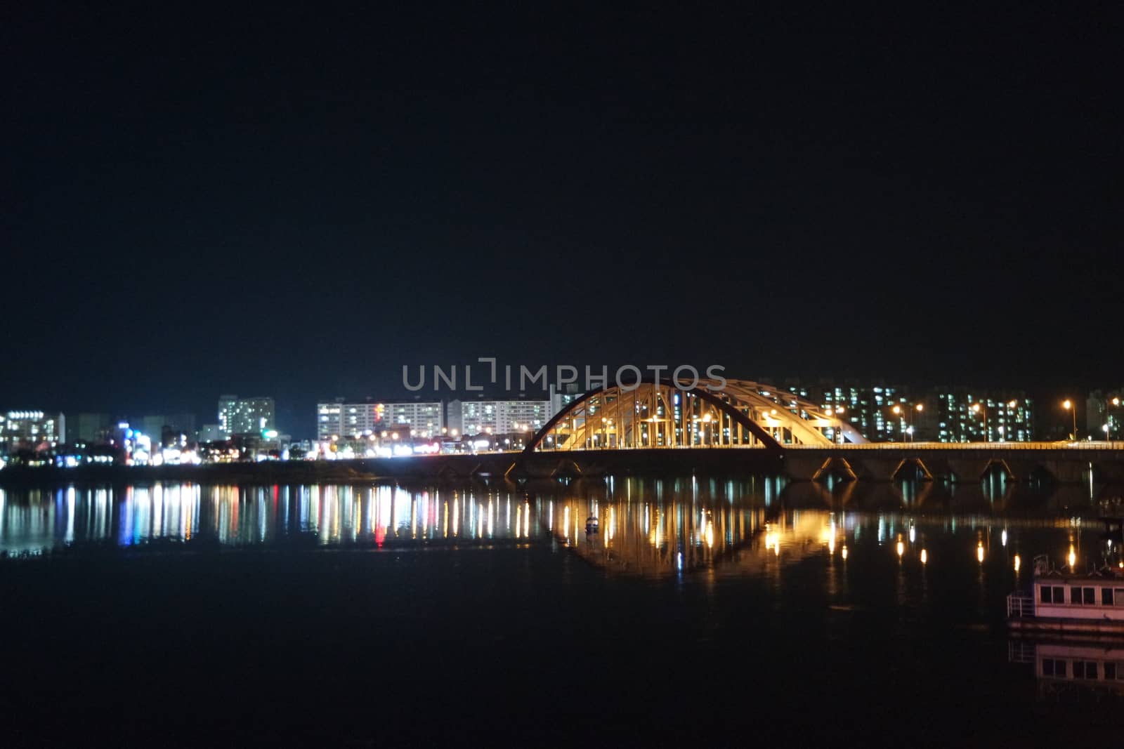 Night view of a beautiful scene of bridge over sea water in the evening time with colorful lights.