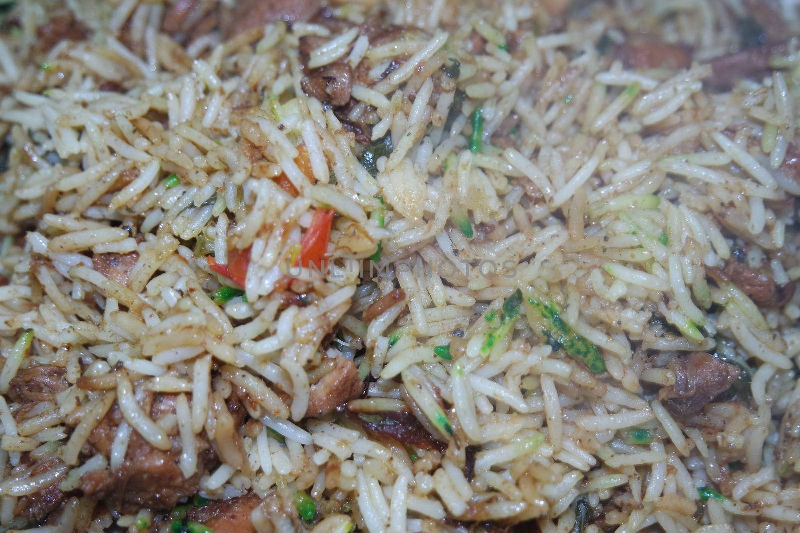 A close up view with selective focus of cooked white Basmati rice pulao or biryani with chicken meat
