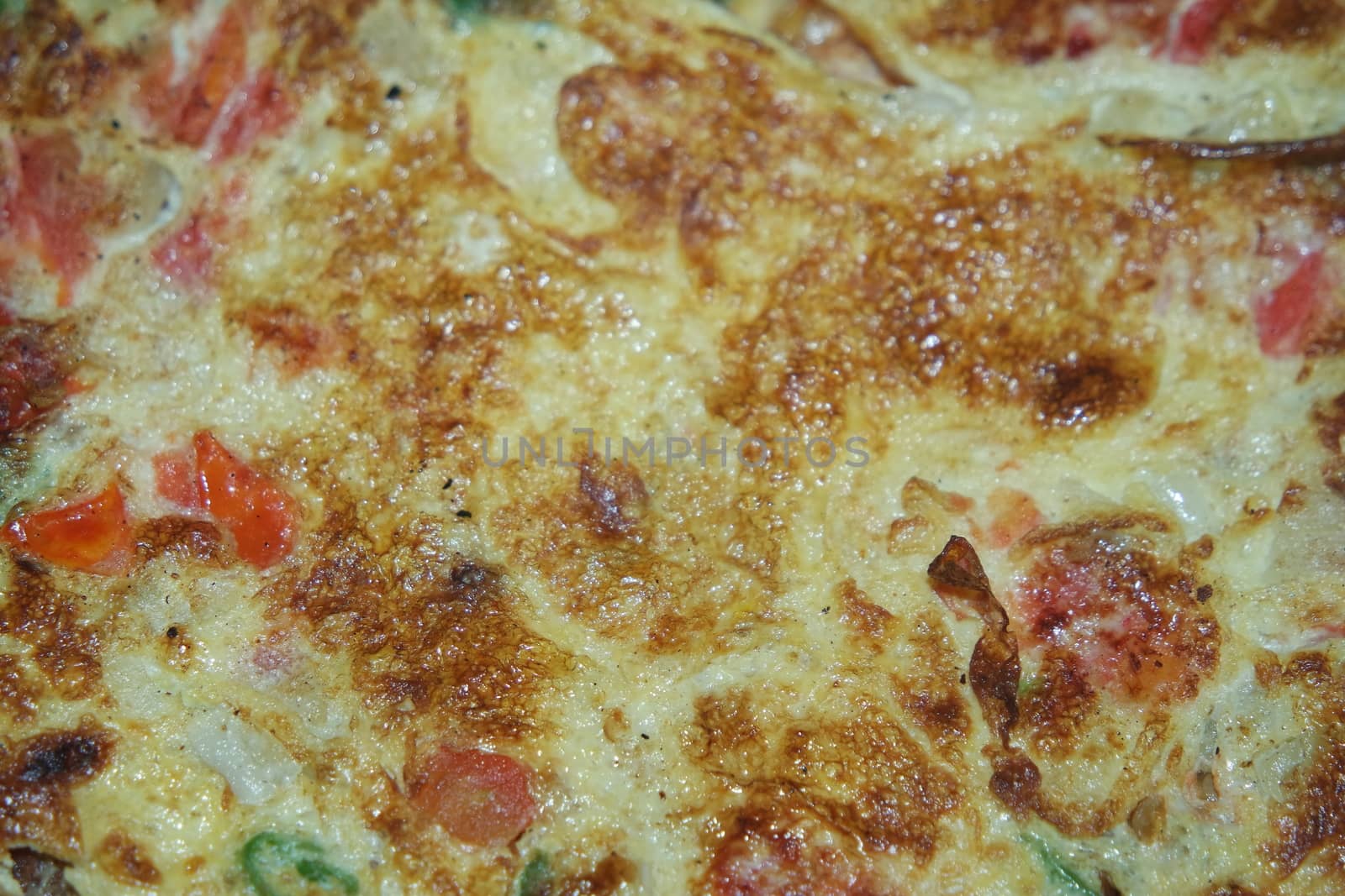 Close-up view with selective focus of egg omelet with peppers and spices sprinkled