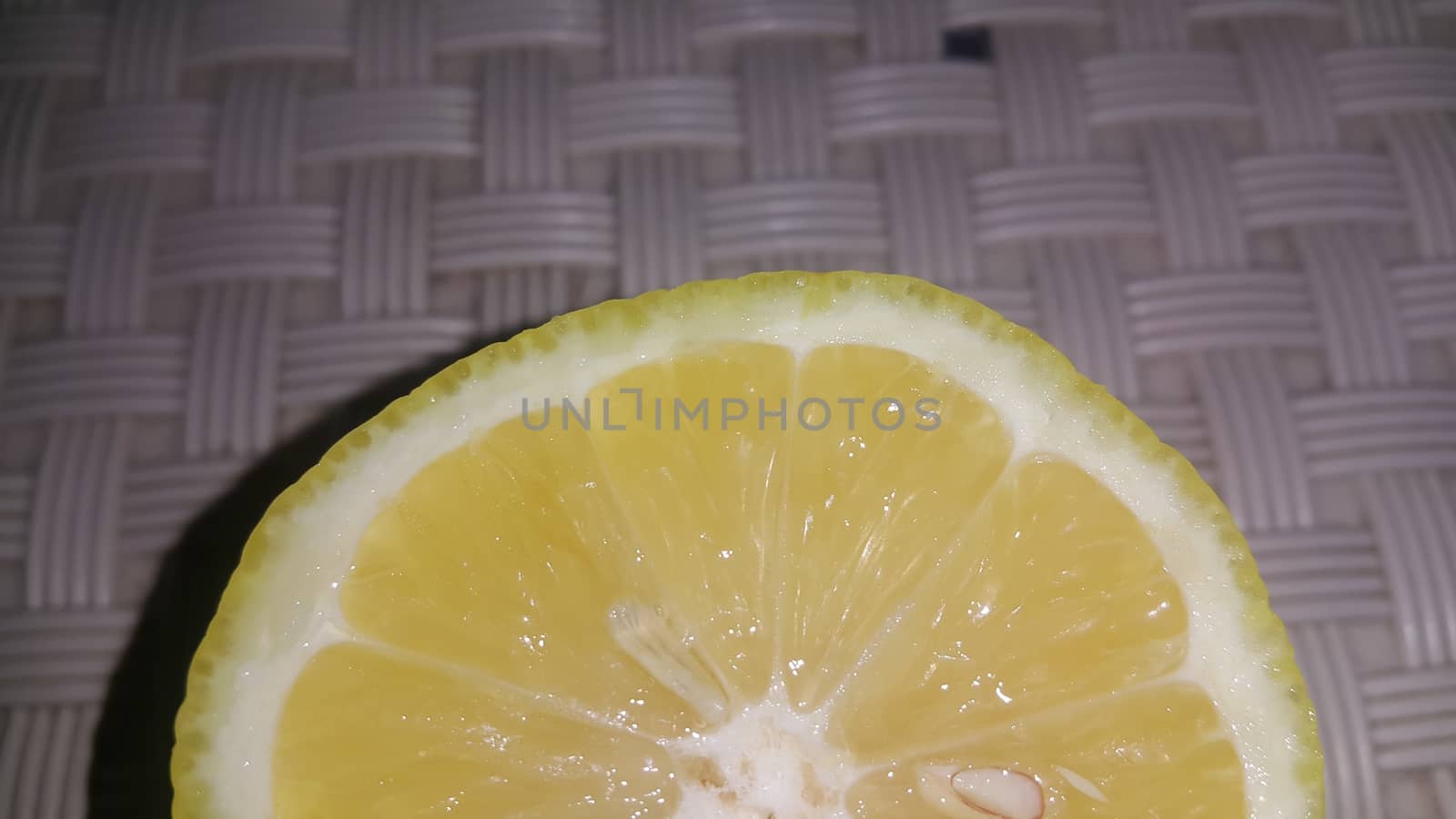 Fresh lemon slices with yellow peelings placed on a grey floor. Top view of fresh juicy lemon slice background
