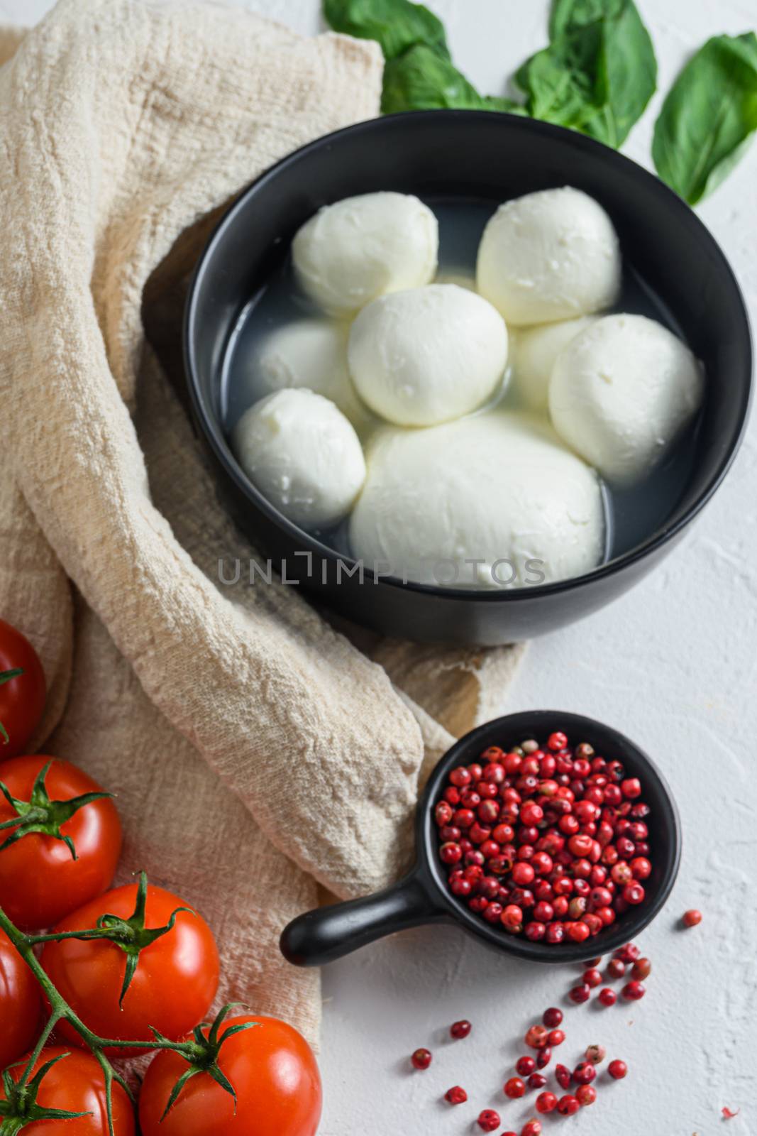 mozzarella buffalo, fresh basil, red tomatoes and olive oil. Italian cuisine, healthy lunch food. Italian caprese salad Ingredients . on cloth and white background by Ilianesolenyi