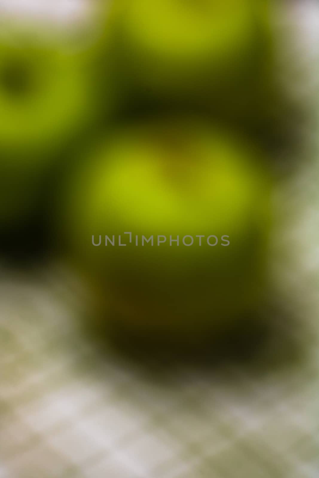 Out of focus, green apples on rustic table napkin. by vladispas