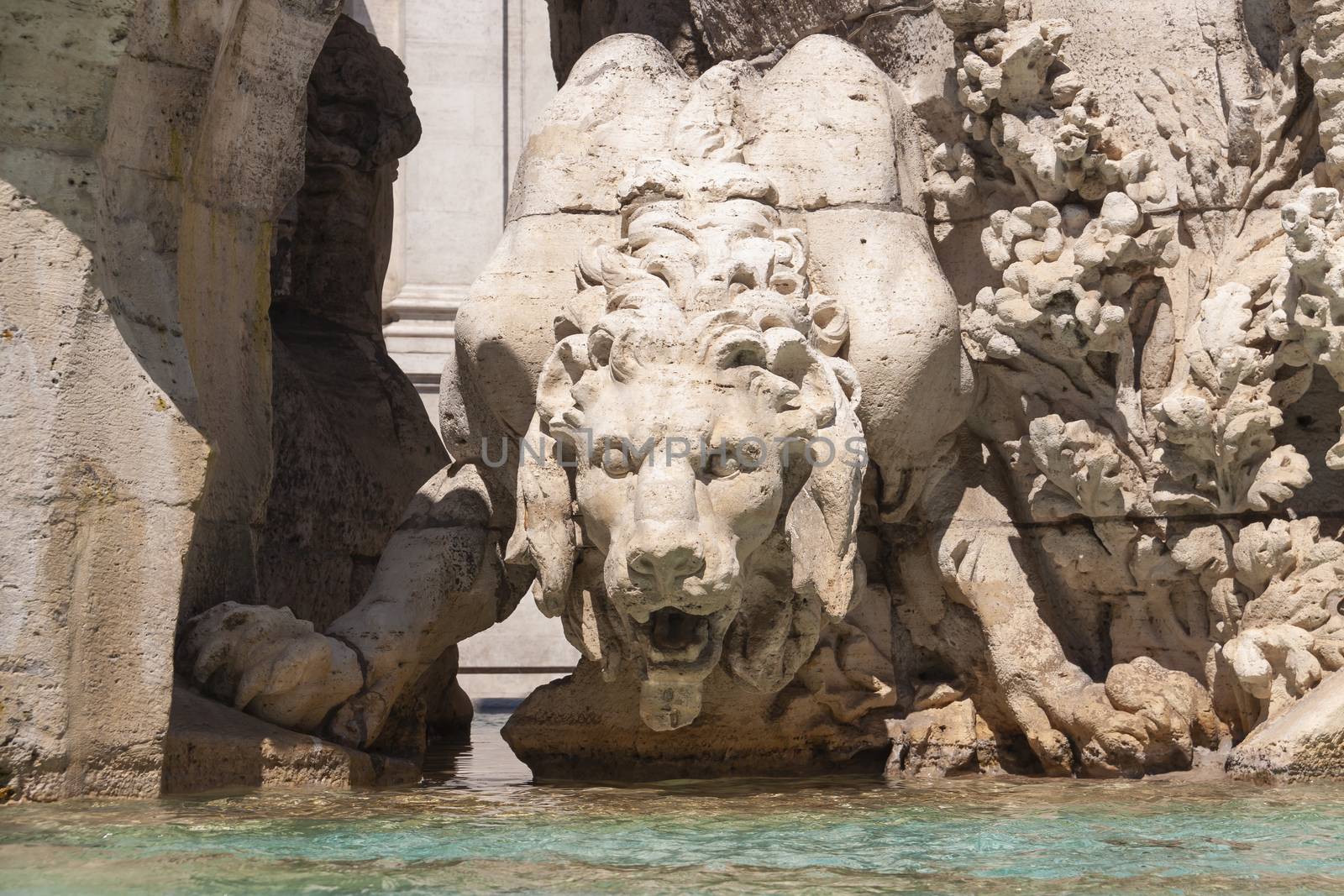 Rome, Italy - June 28, 2010: Statue of a menacing lion, drinking water at the Fountain of the Four Rivers, Piazza Navona, Rome.