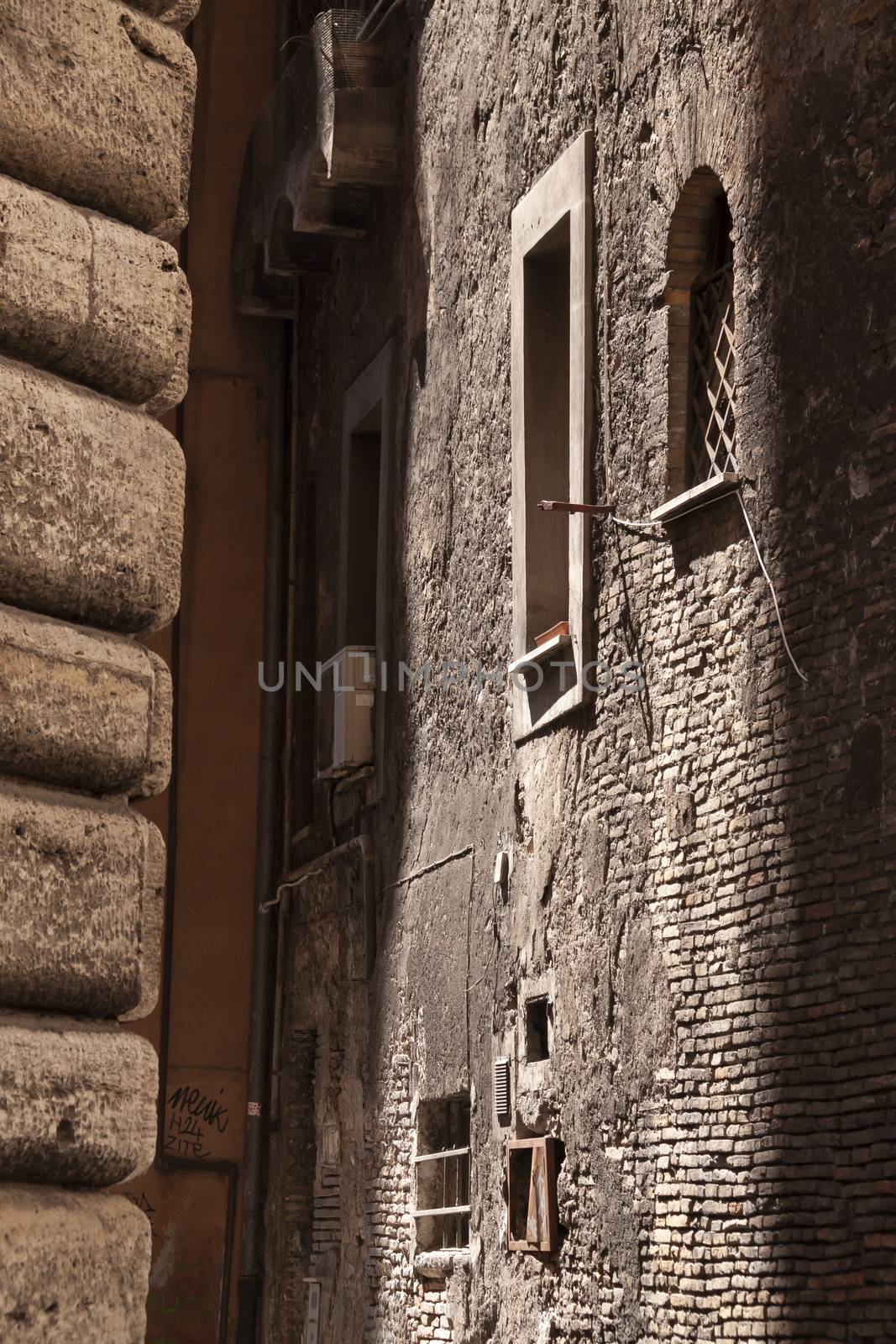 Rome, Italy - June 28, 2010: Old houses and walls in an alleyway between two streets in the center of Rome.