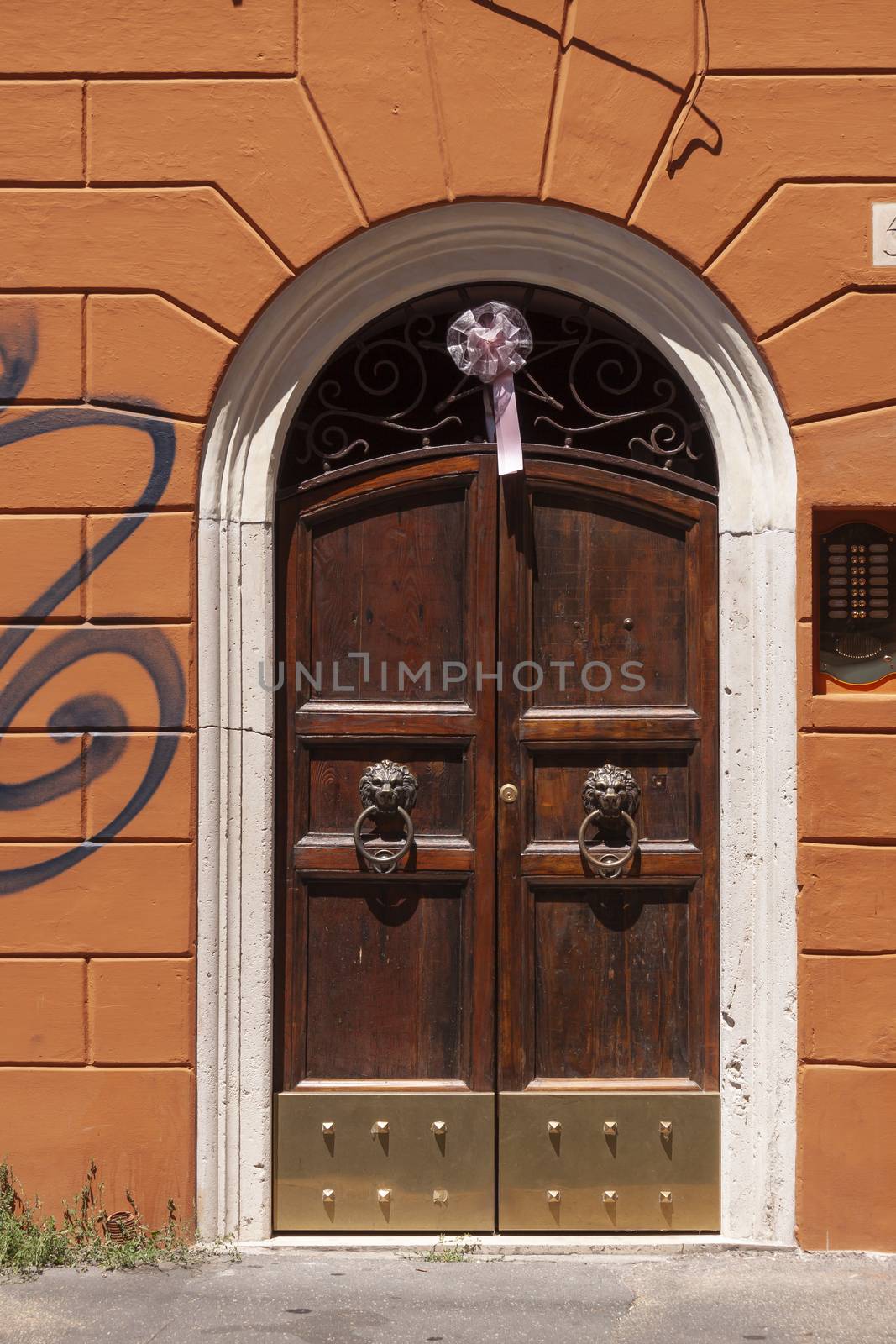 Rome, Italy - June 28, 2010: A closed, double leaf, dark wooden door on a sunny day in the center of Rome, Trastevere area.