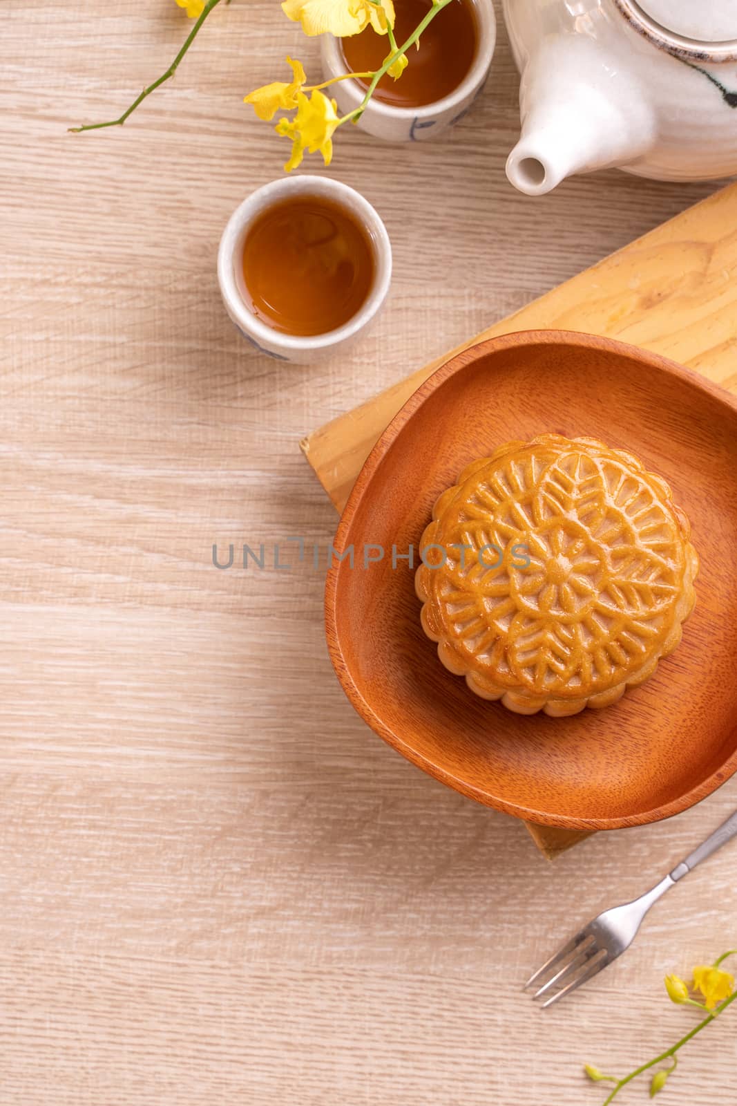 Mid-Autumn Festival holiday concept design of moon cake, mooncakes, tea set on bright wooden table with copy space, top view, flat lay, overhead shot