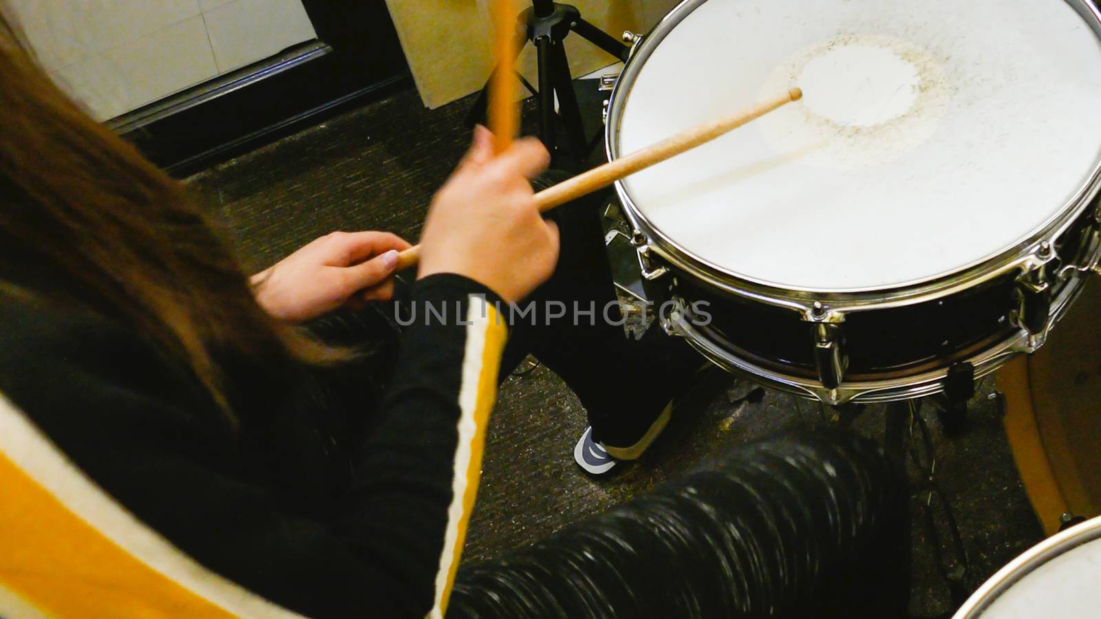 Sticks playing drums on drumkit