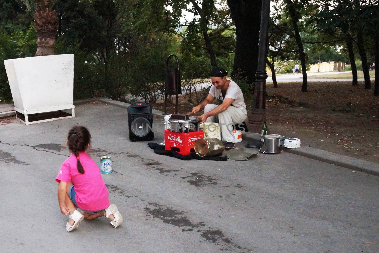 Varna, Bulgaria - September, 06, 2020: street drummer playing in the park with improvised means